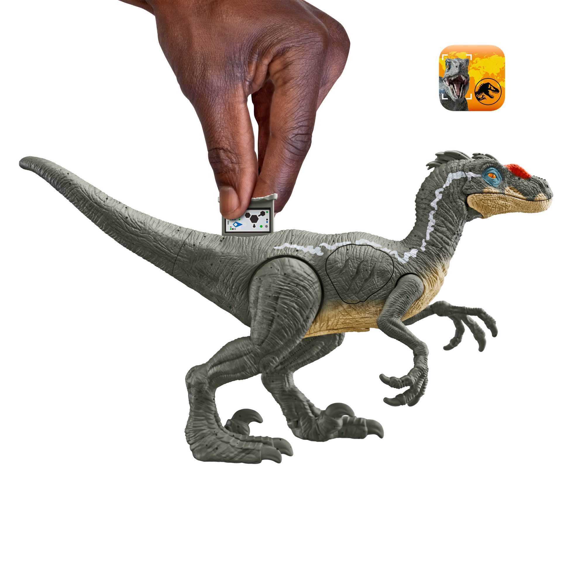 Una mano sostiene un pequeño dispositivo sobre un juguete de dinosaurio. El juguete es gris y detallado.