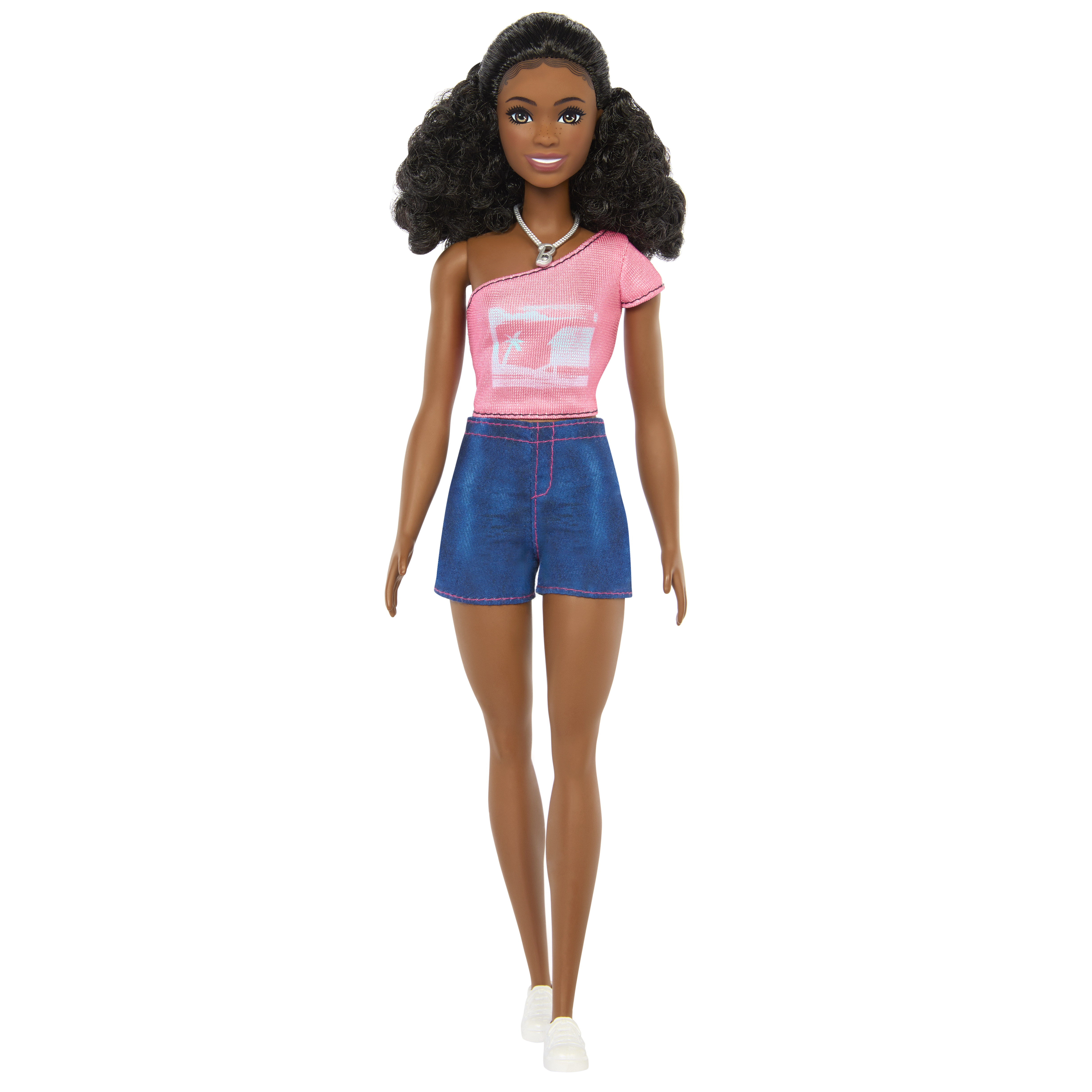 Eine Puppe trägt ein rosa Oberteil und Jeansshorts. Die Puppe hat schwarze Haare und weiße Schuhe.
