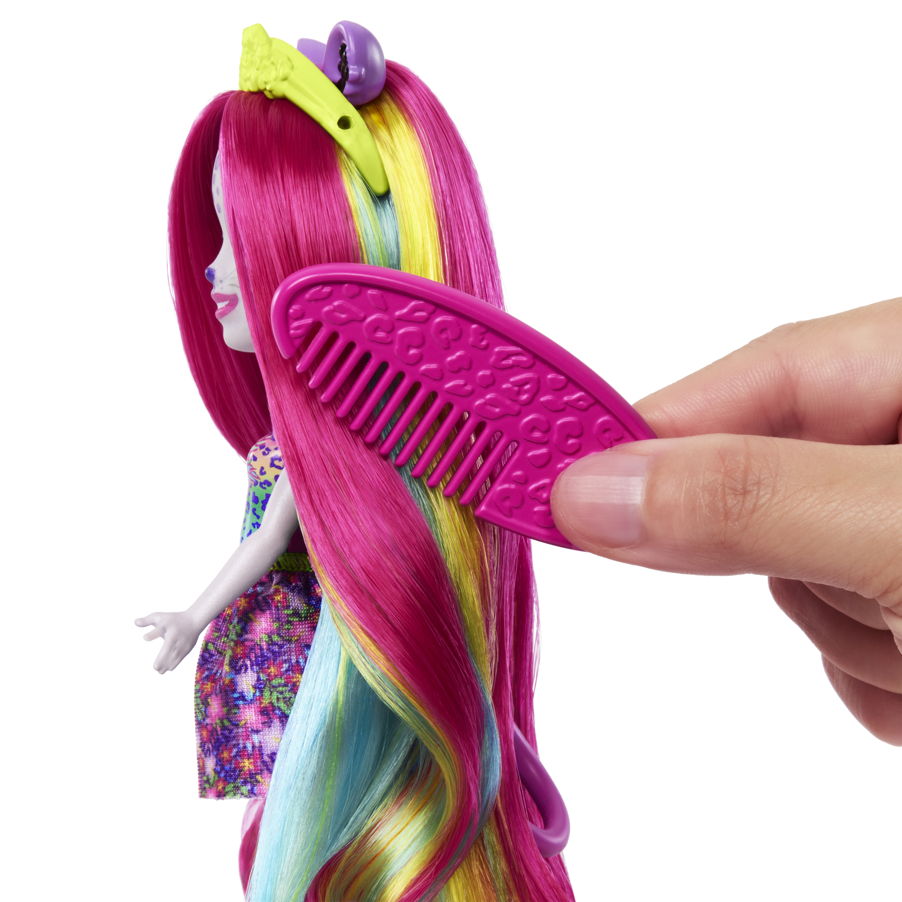 Lalka z różowymi, żółtymi i niebieskimi włosami jest czesana. Ręka trzyma różowy grzebień.