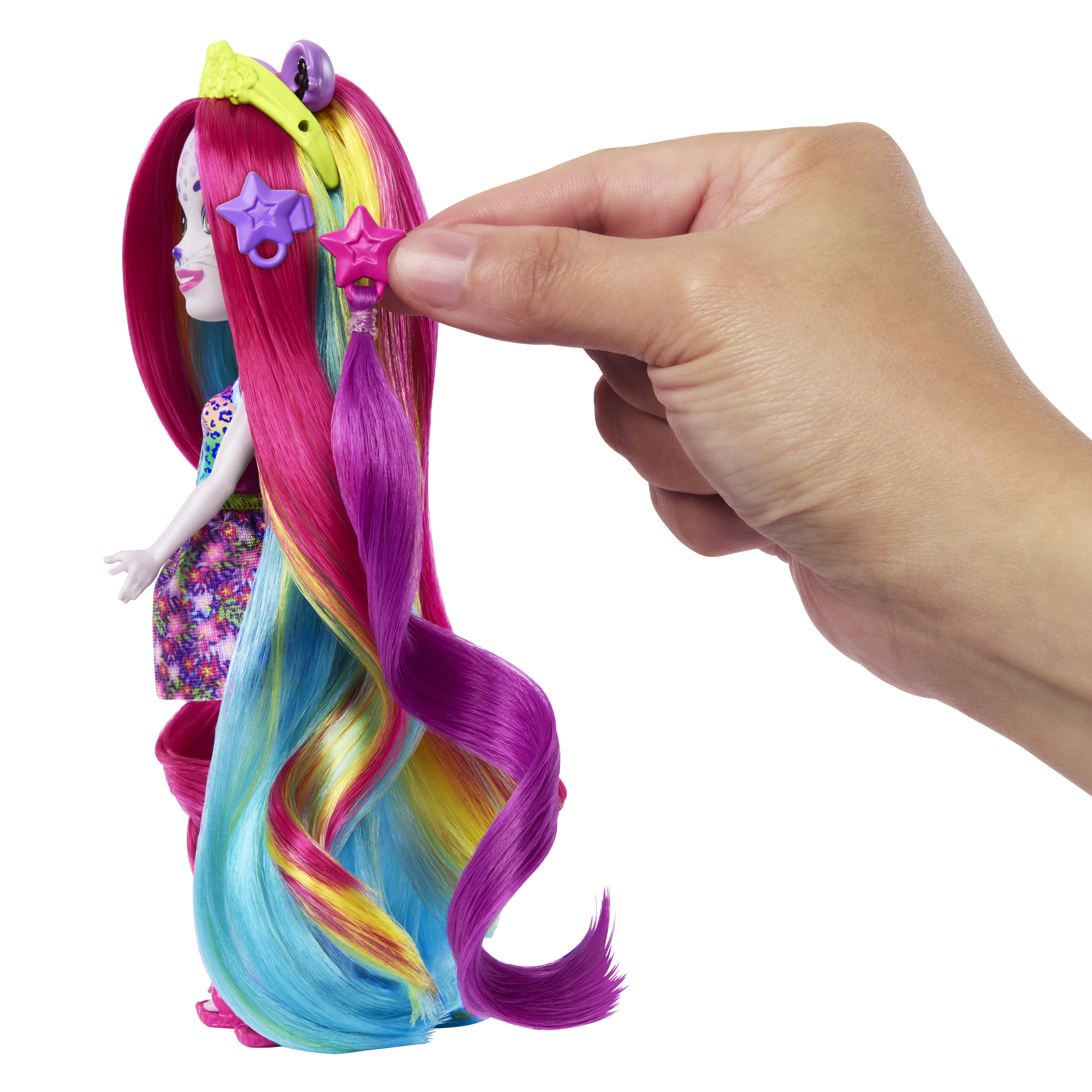 Lalka z kolorowymi włosami, dłoń trzymająca akcesorium w kształcie gwiazdy, białe tło.