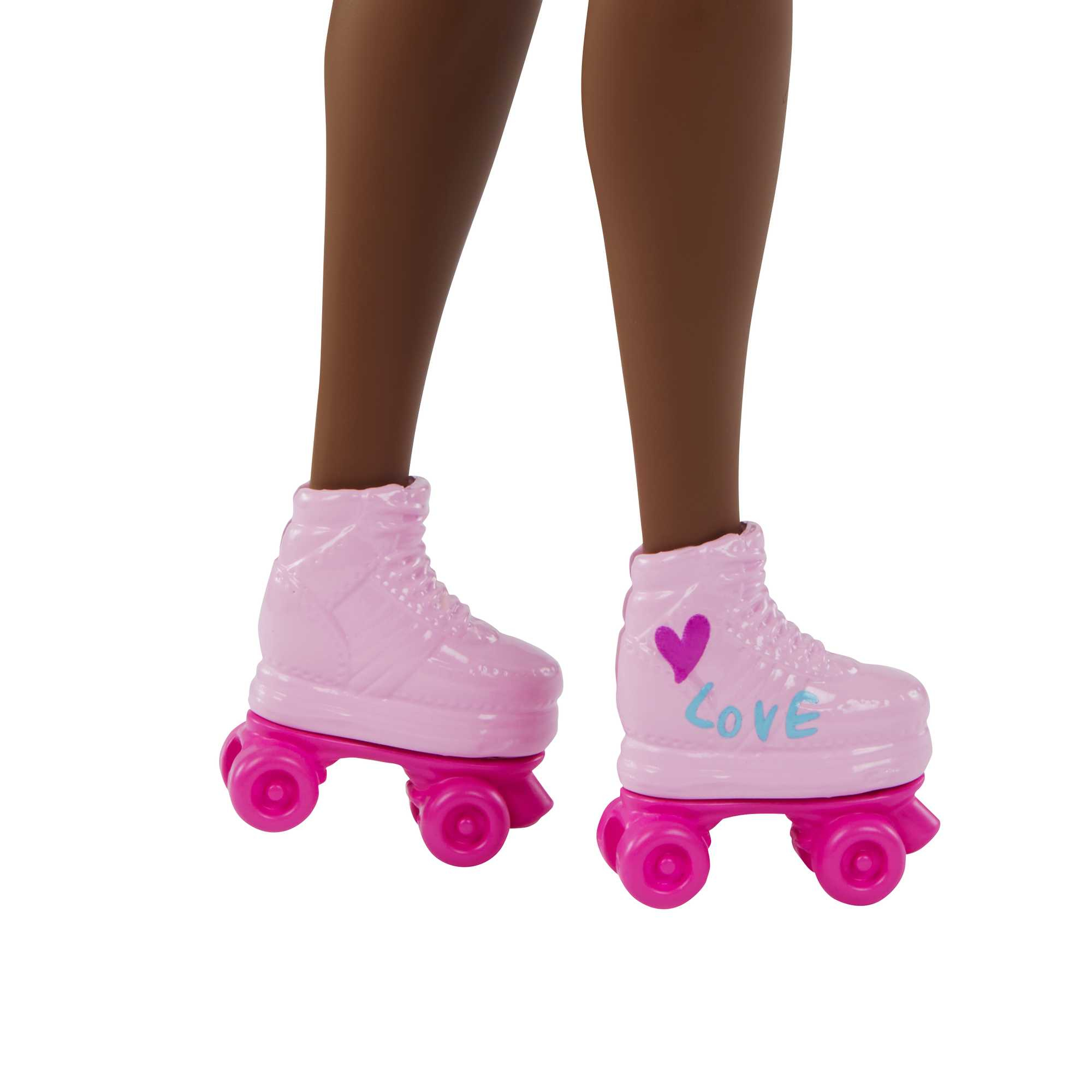 Rosa Rollschuhe mit rosa Rädern an braunen Beinen, einer mit 'Love' darauf.