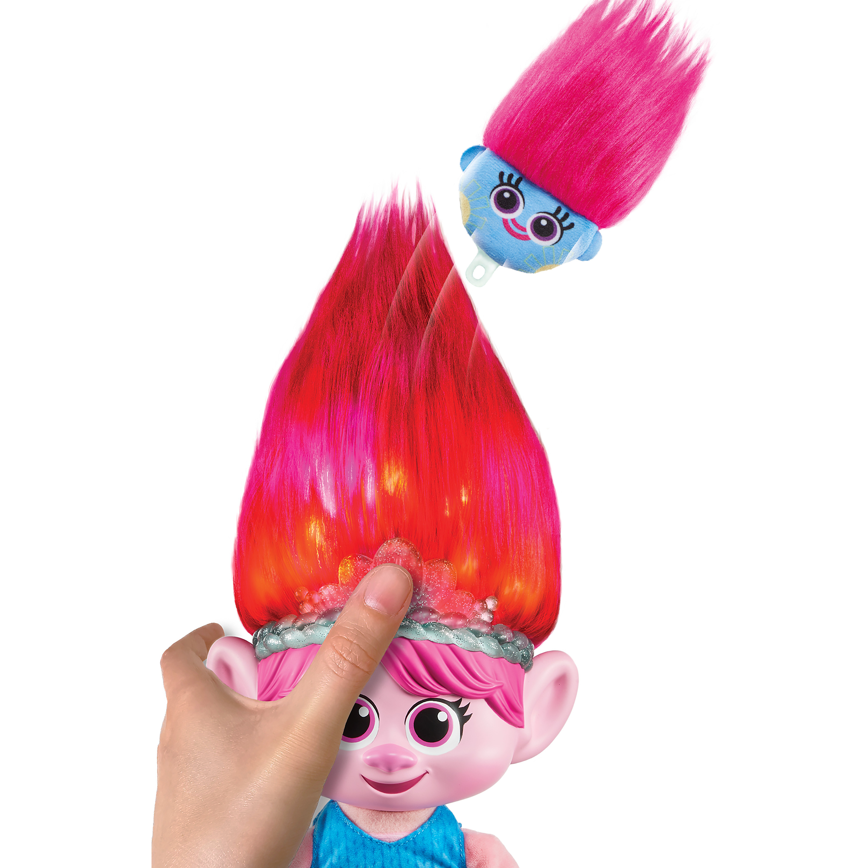 Ein Trolls-Spielzeug. Eine Hand zieht einen Kopf von einer Puppe ab und zeigt eine hellere Haarfarbe darunter.
