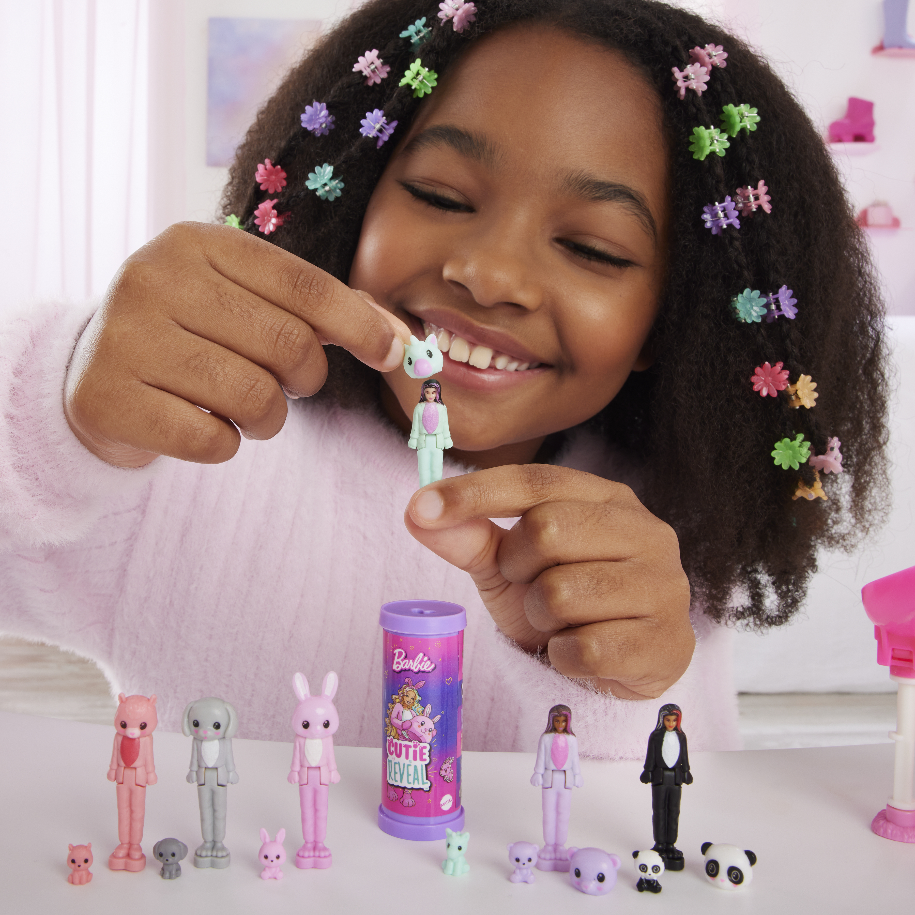 Ein Mädchen spielt mit Barbie Cutie Reveal-Puppen und Zubehör. Es gibt mehrere Puppen und Zubehör.