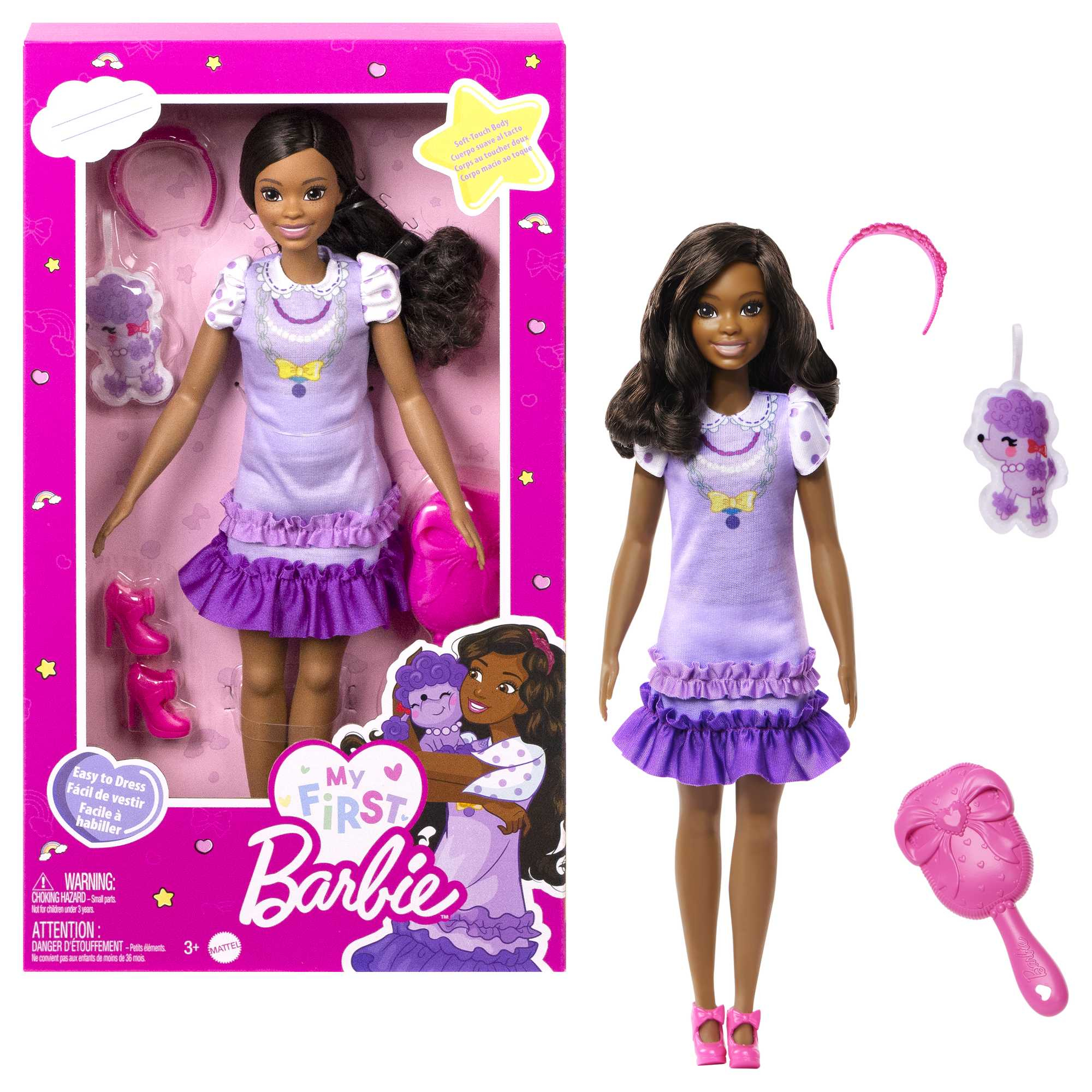 Una muñeca My First Barbie. Tiene un vestido morado y accesorios. La muñeca es negra.