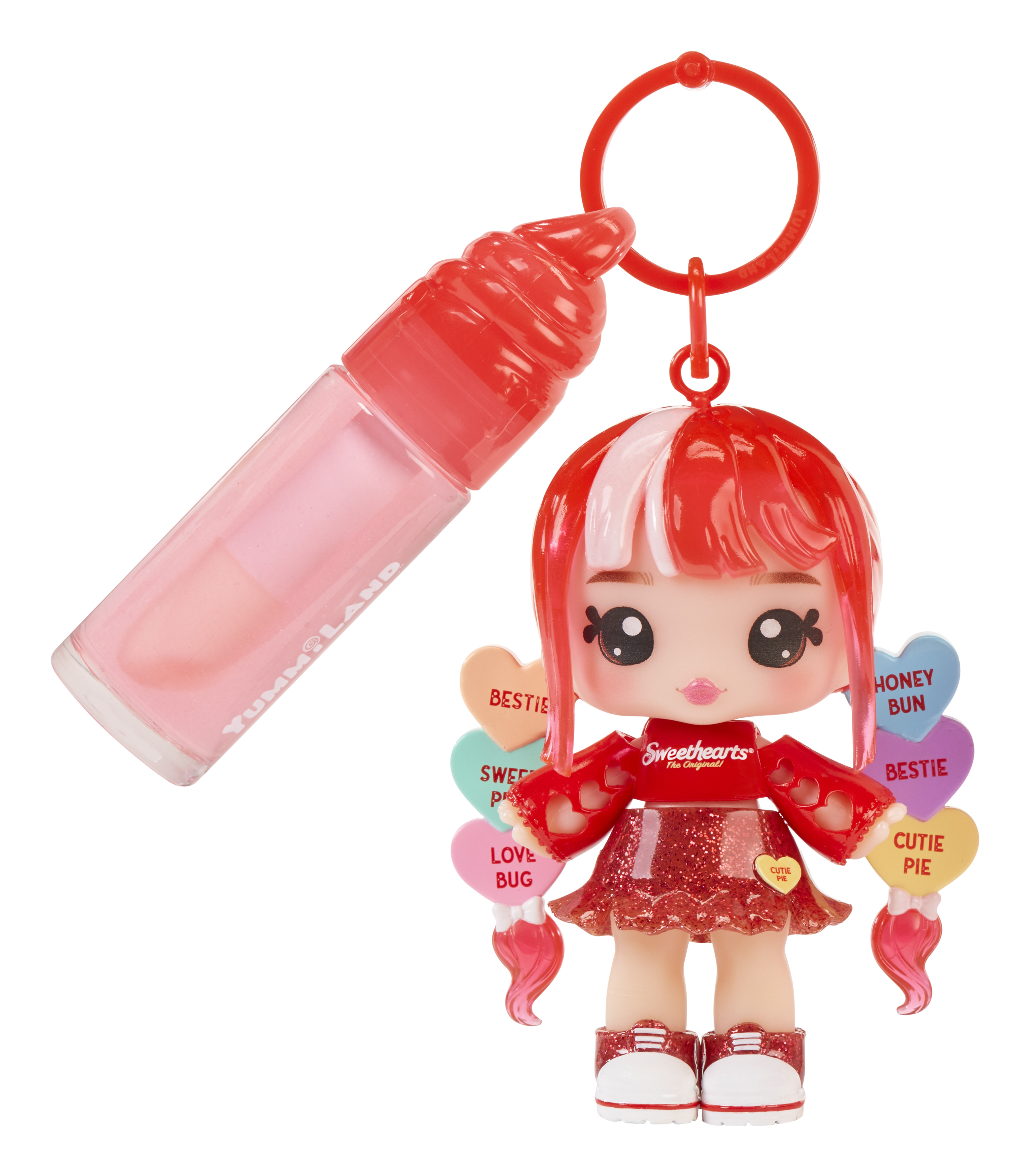 Puppe mit rotem Haar, herzförmigen Süßigkeiten und Lipgloss. Weißer Hintergrund.