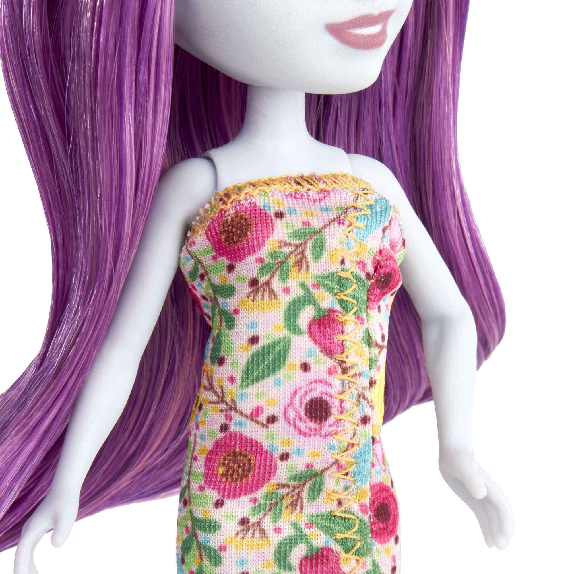 Lalka z fioletowymi włosami i kwiatową sukienką. Tło jest białe.