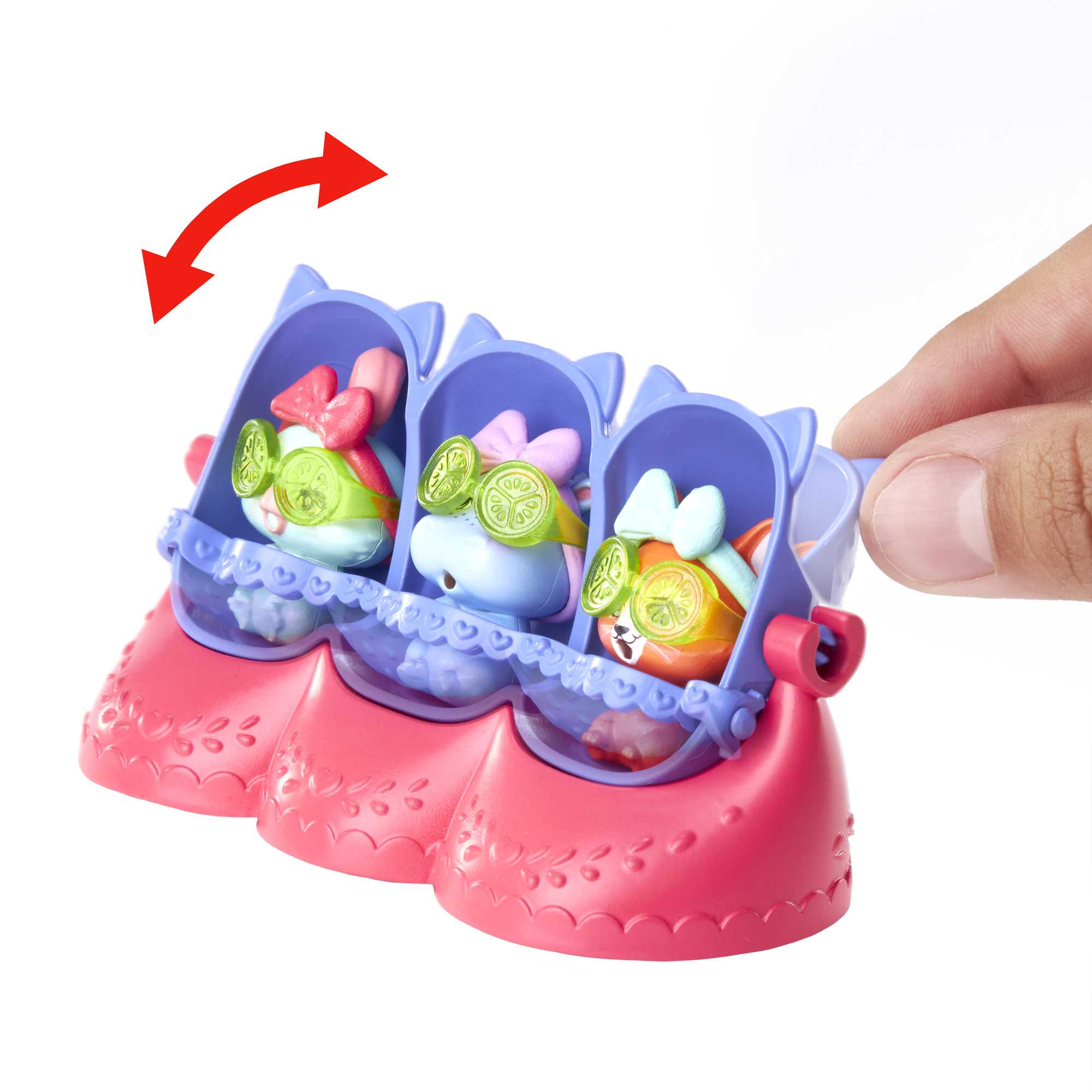 Ręka obracająca zabawkę z trzema figurkami zwierząt w maskach spa. Zabawka jest różowa.