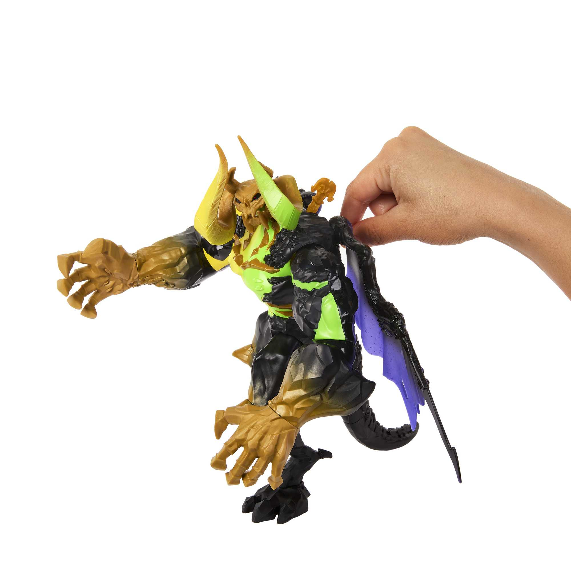 Zabawkowa figurka potwornego stworzenia trzymana przez dłoń. Ciemne kolory z zielonymi i złotymi akcentami.