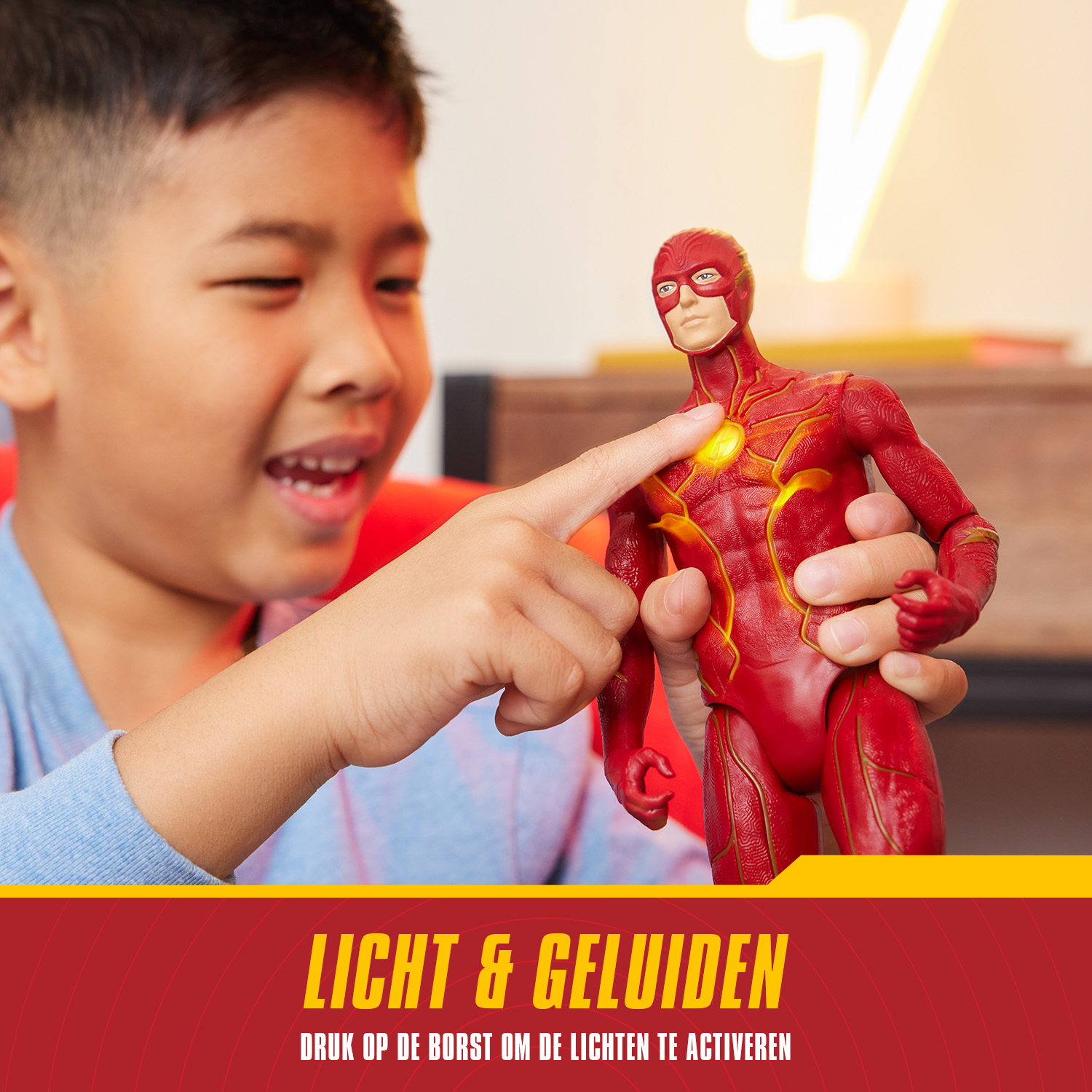 Chłopiec wskazujący na figurkę Flasha. Kolory czerwony i żółty.