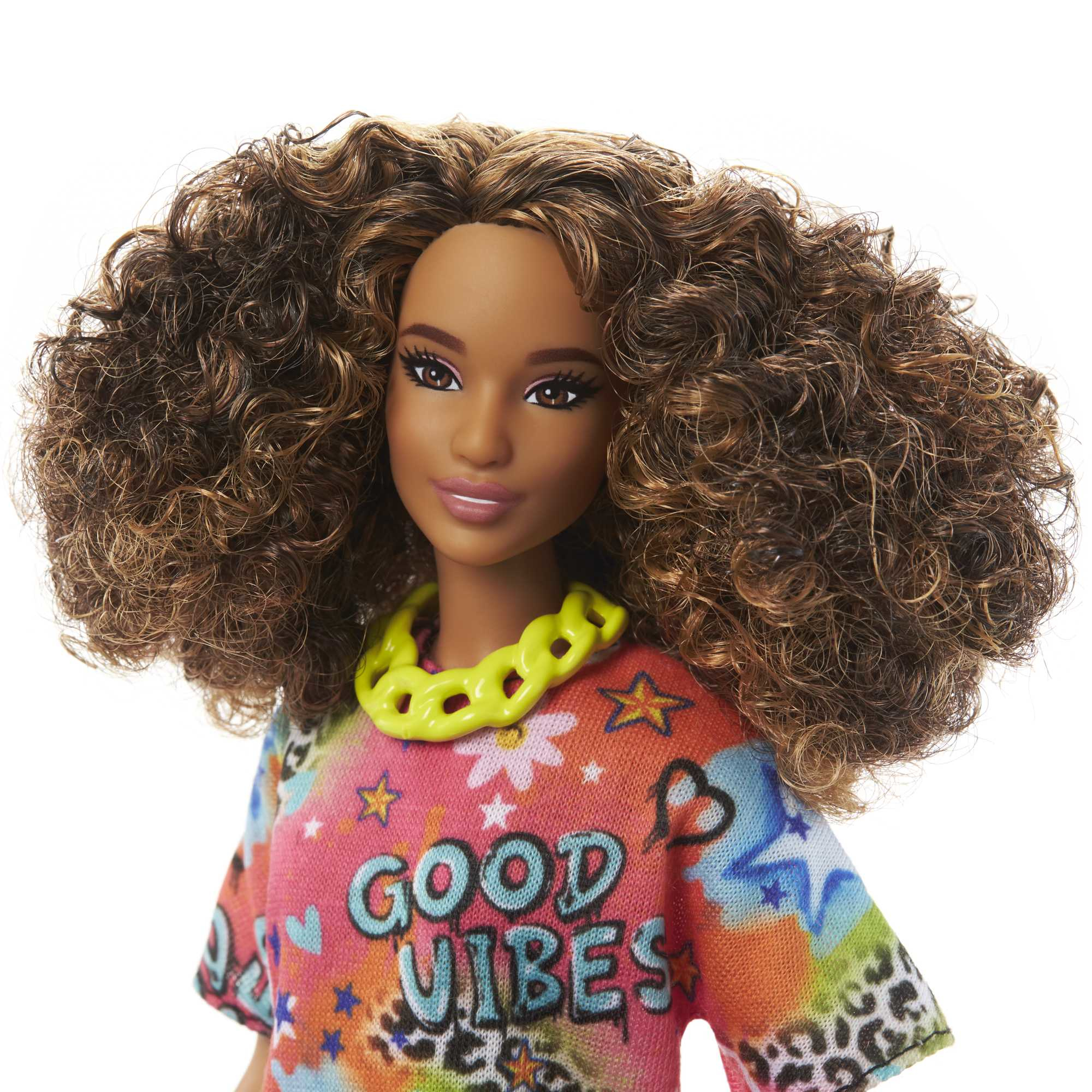Nahaufnahme einer Barbie-Puppe mit lockigem braunem Haar, die ein buntes Oberteil trägt. Weißer Hintergrund.
