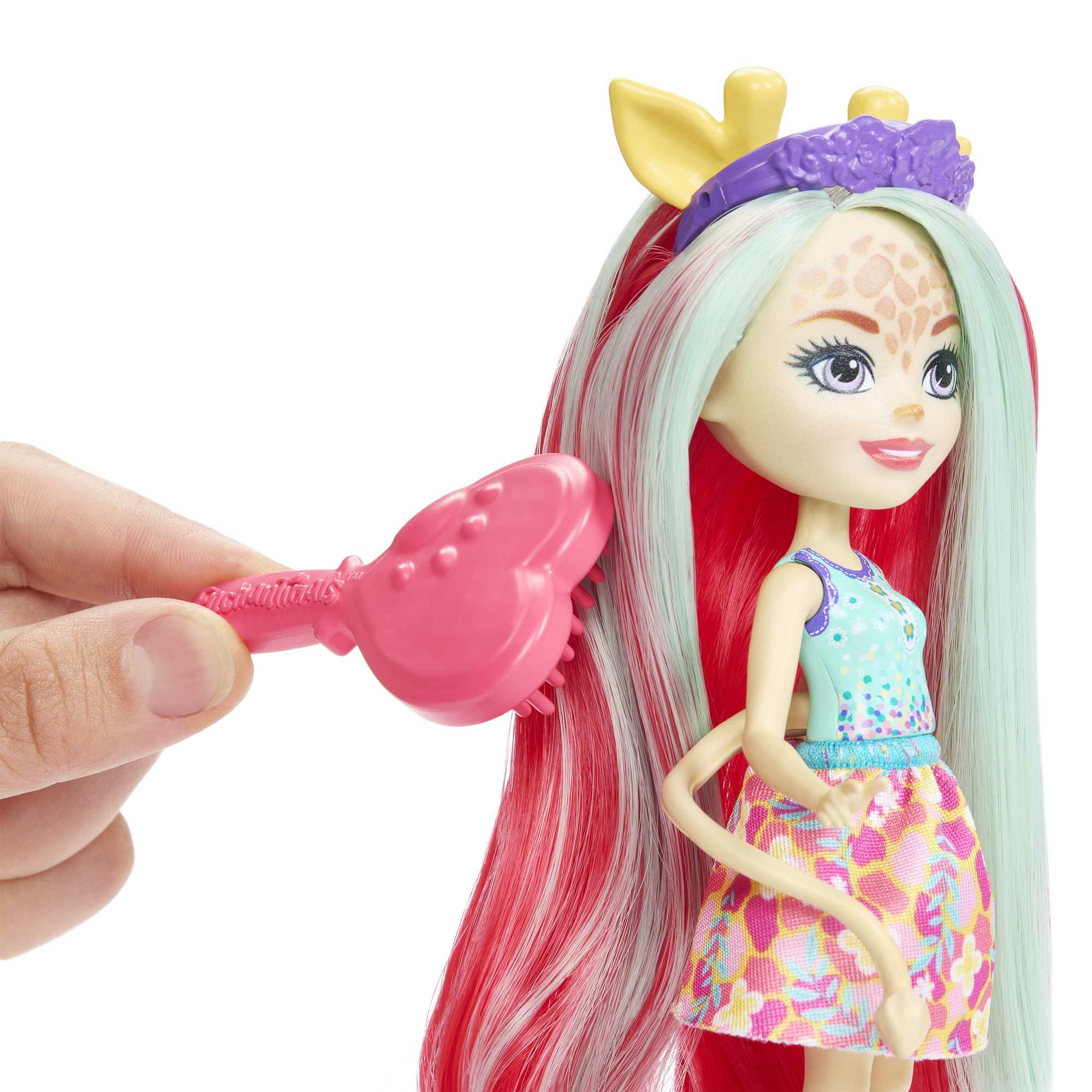 Lalka z długimi czerwonymi i miętowymi włosami jest czesana przez rękę. Lalka ma motyw żyrafy.