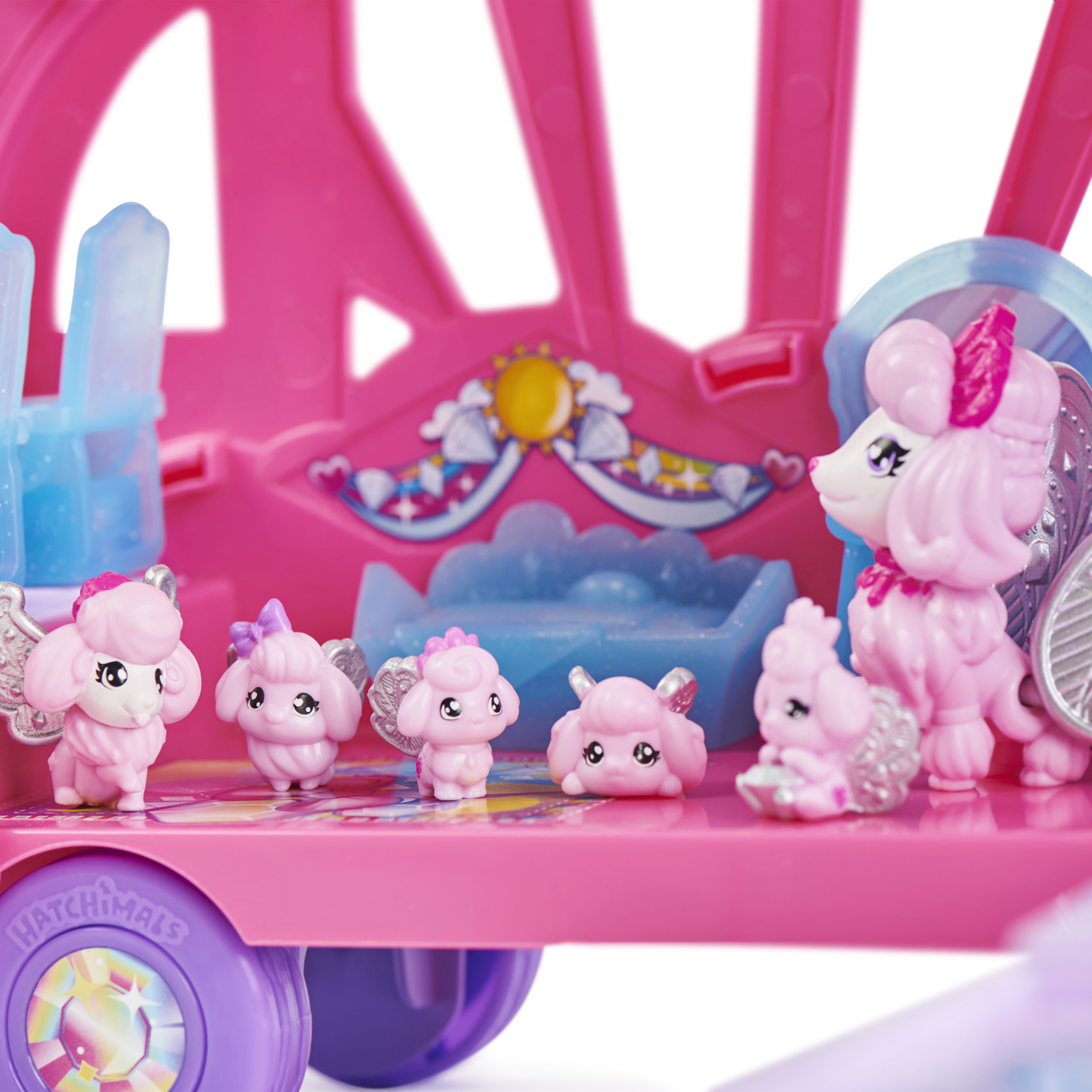 Zestaw zabawek z różowymi figurkami pudli na różowym wozie.