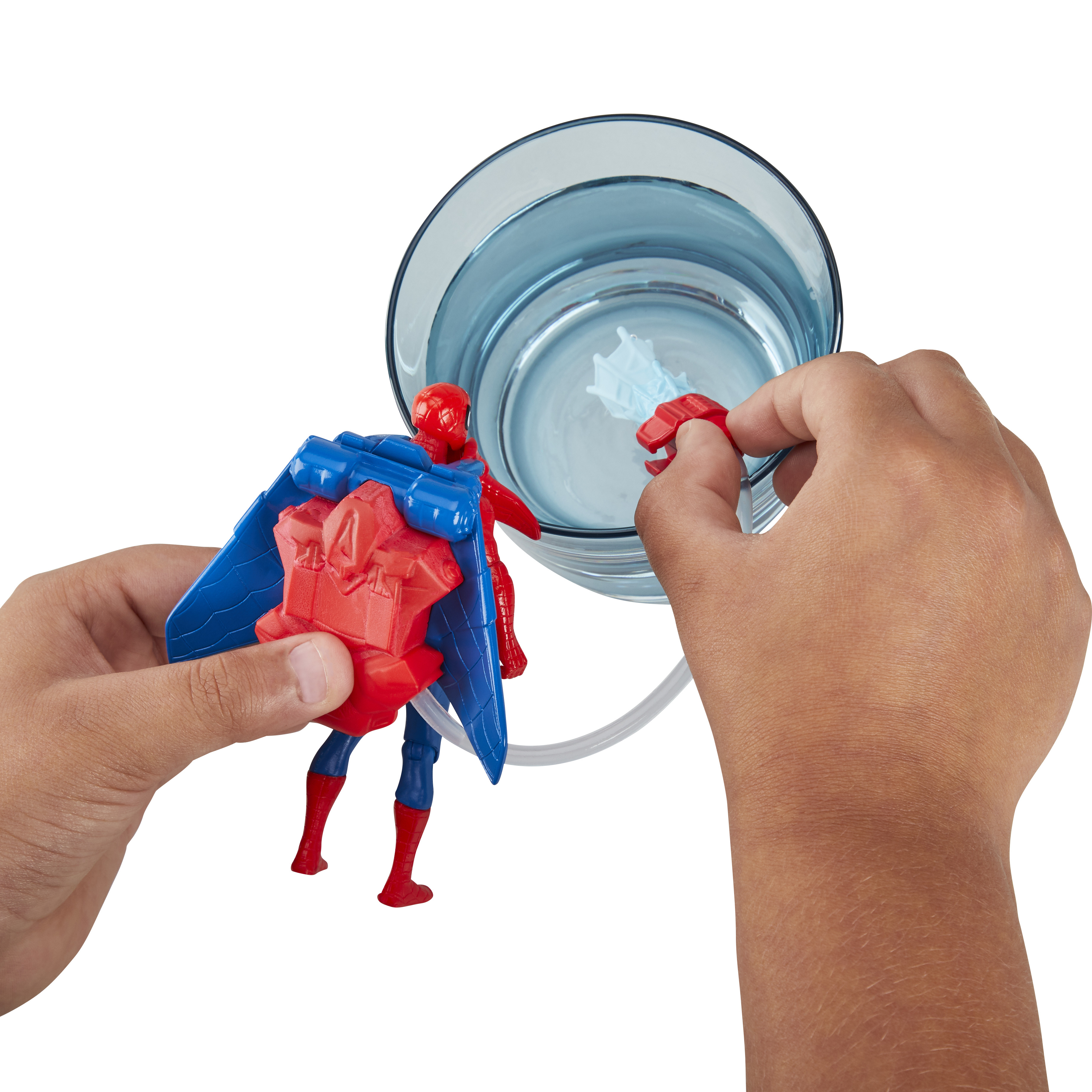 Le mani di un bambino tengono una action figure di Spider-Man e un accessorio a getto d'acqua vicino a un bicchiere.