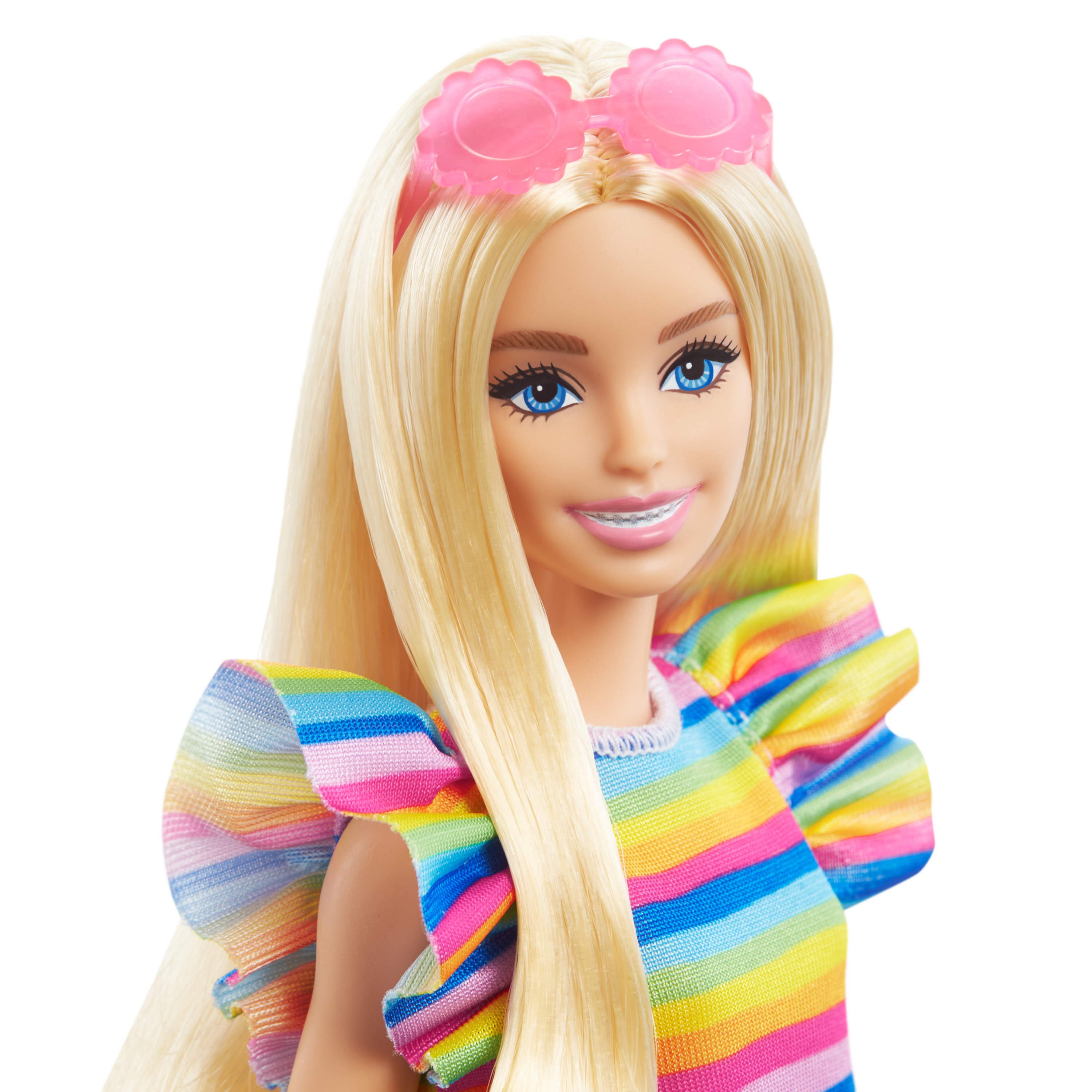 Nahaufnahme eines blonden Barbie-Gesichts, lächelnd, mit rosa Sonnenbrille und einem bunten gestreiften Kleid.