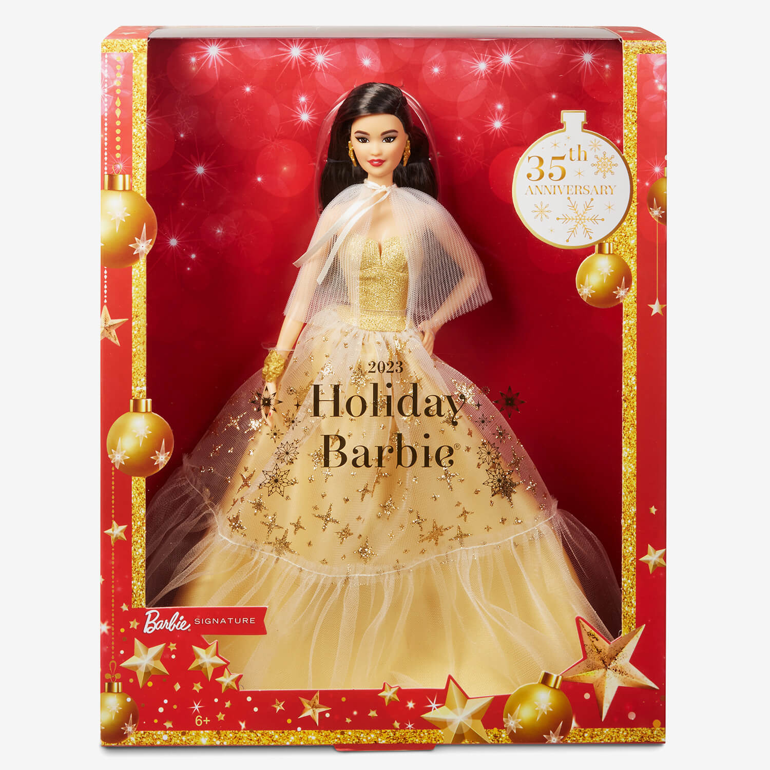 Eine Holiday Barbie-Puppe in einem goldenen Kleid in einer festlichen Box mit rotem Hintergrund und goldenen Ornamenten.