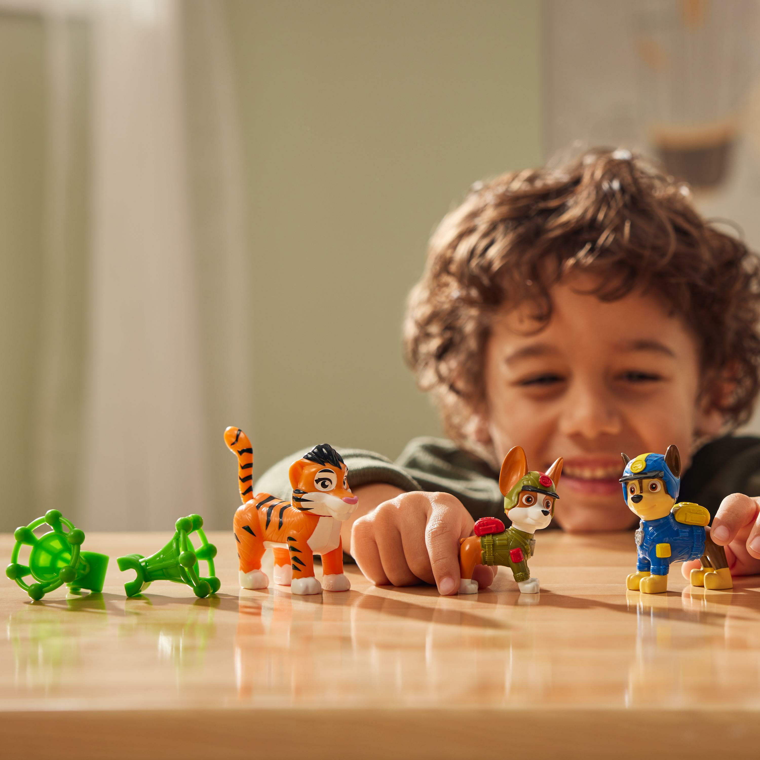 Ein Kind spielt mit Paw Patrol Jungle Pups Figuren von Chase, Tracker und einem Tiger.
