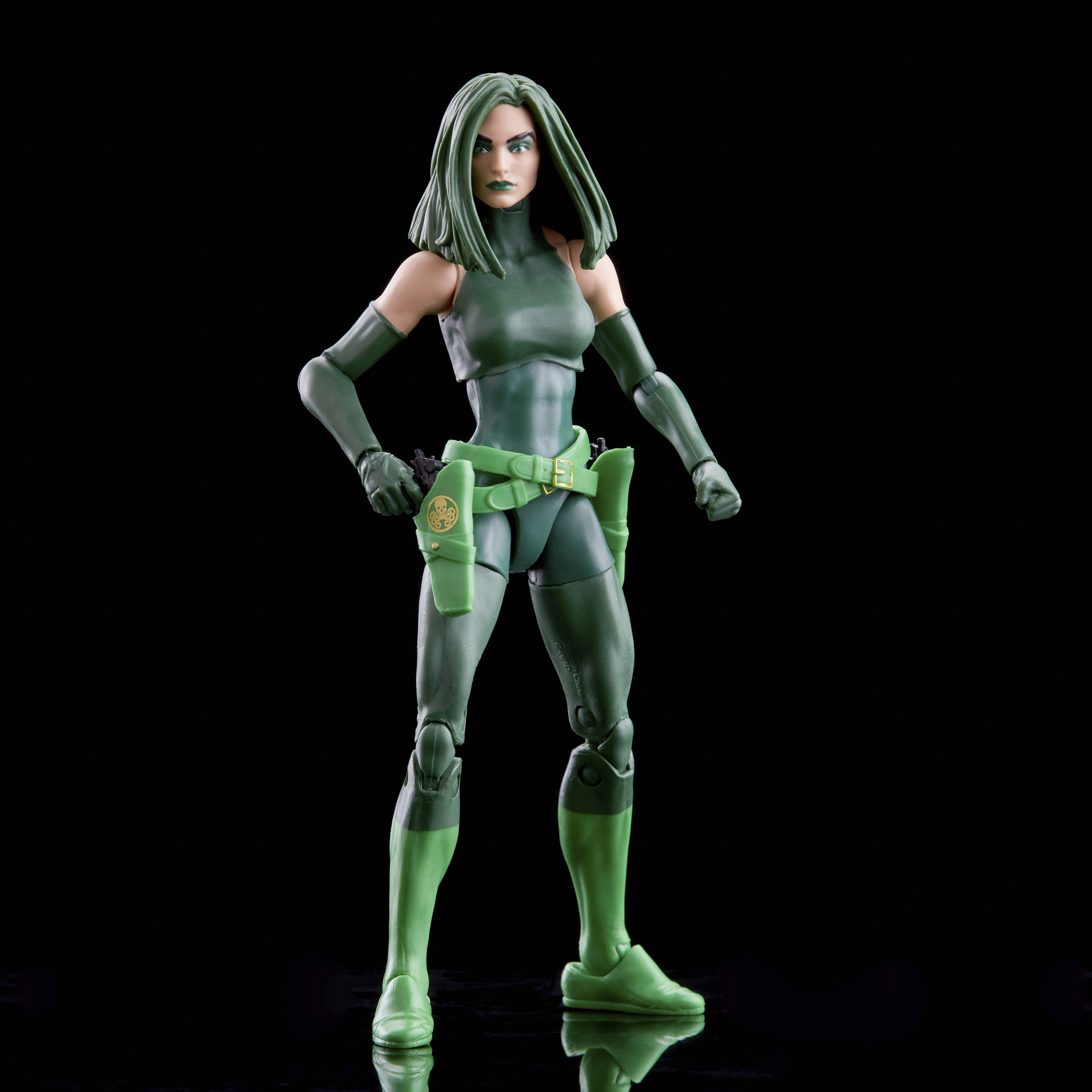 Figura de acción femenina verde sobre fondo negro.
