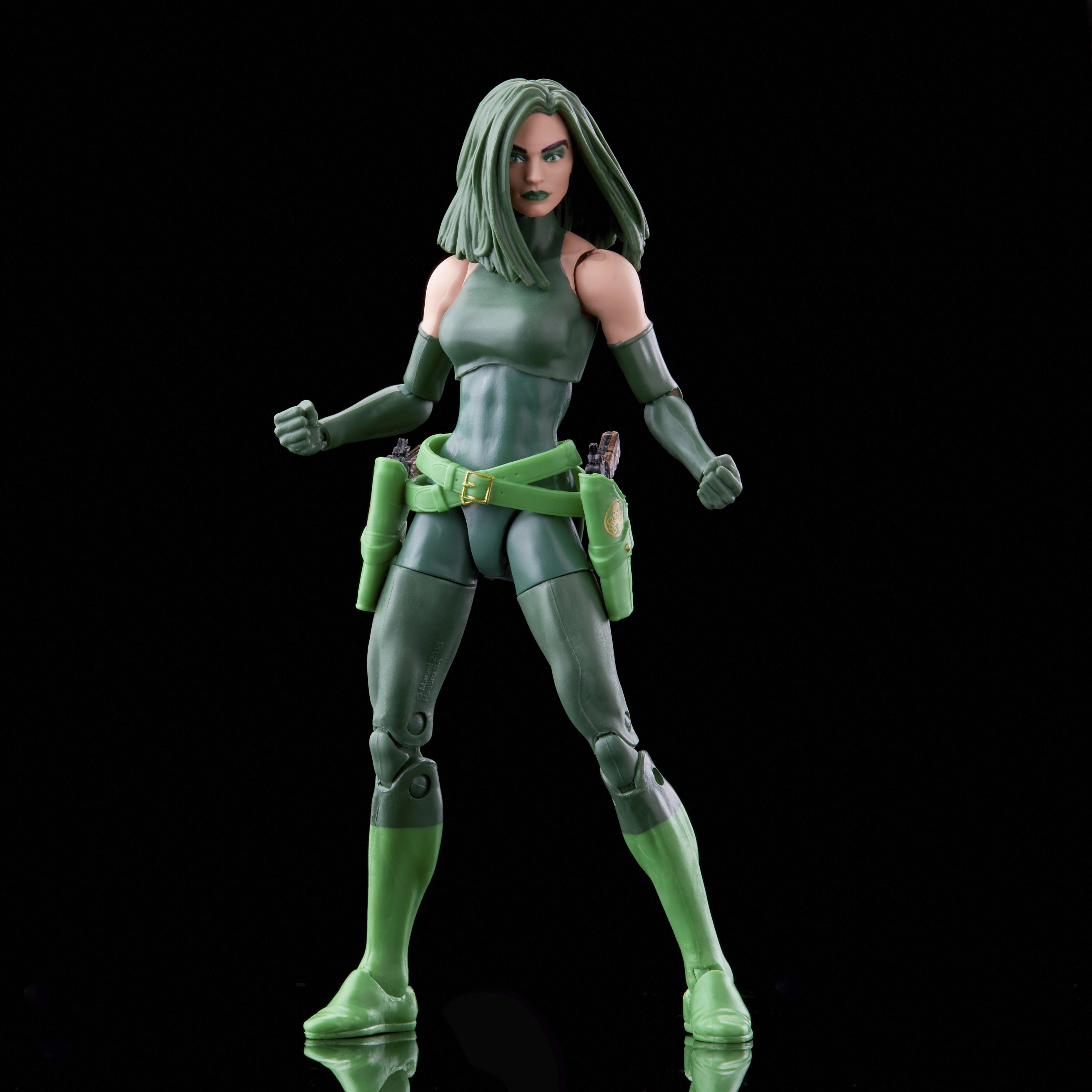 Figura de acción femenina verde sobre fondo negro.