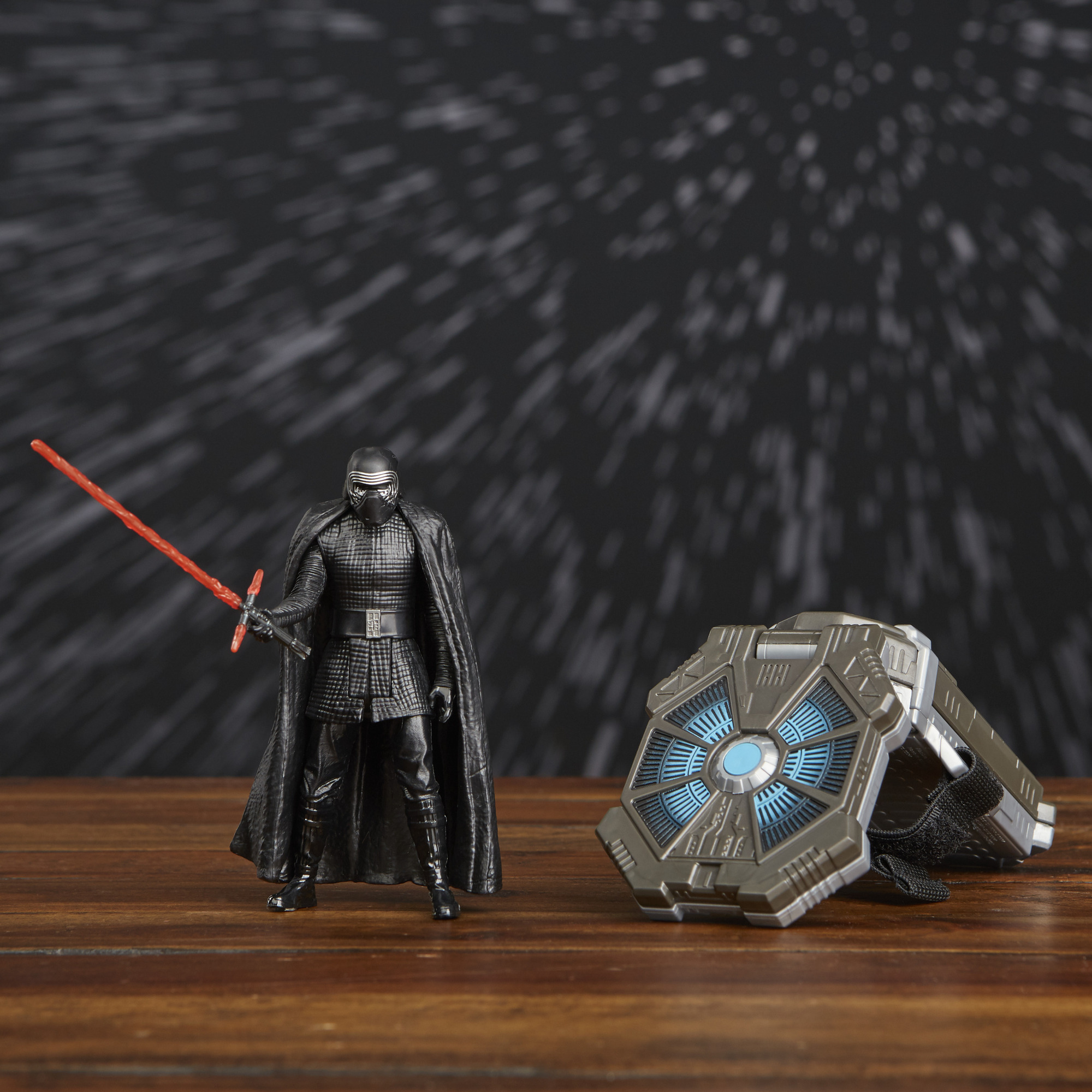 Action figure di Kylo Ren con una spada laser rossa e un dispositivo a forma di scudo su legno.