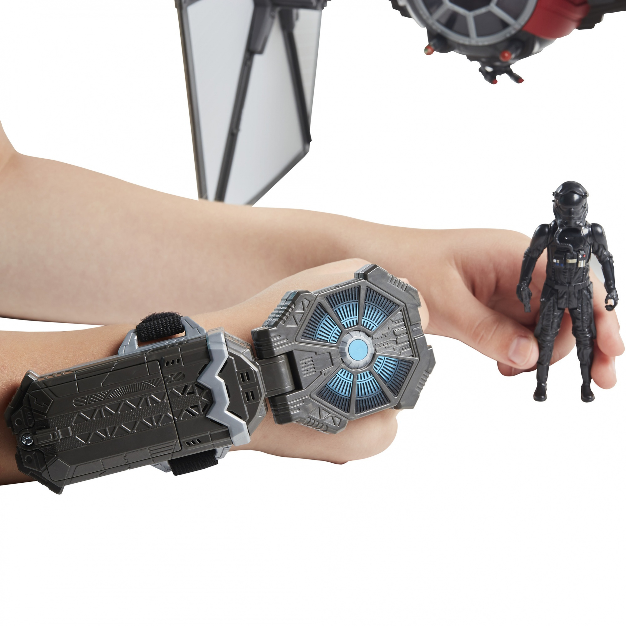 Le mani di un bambino che tengono un dispositivo da polso e una action figure nera con un casco.