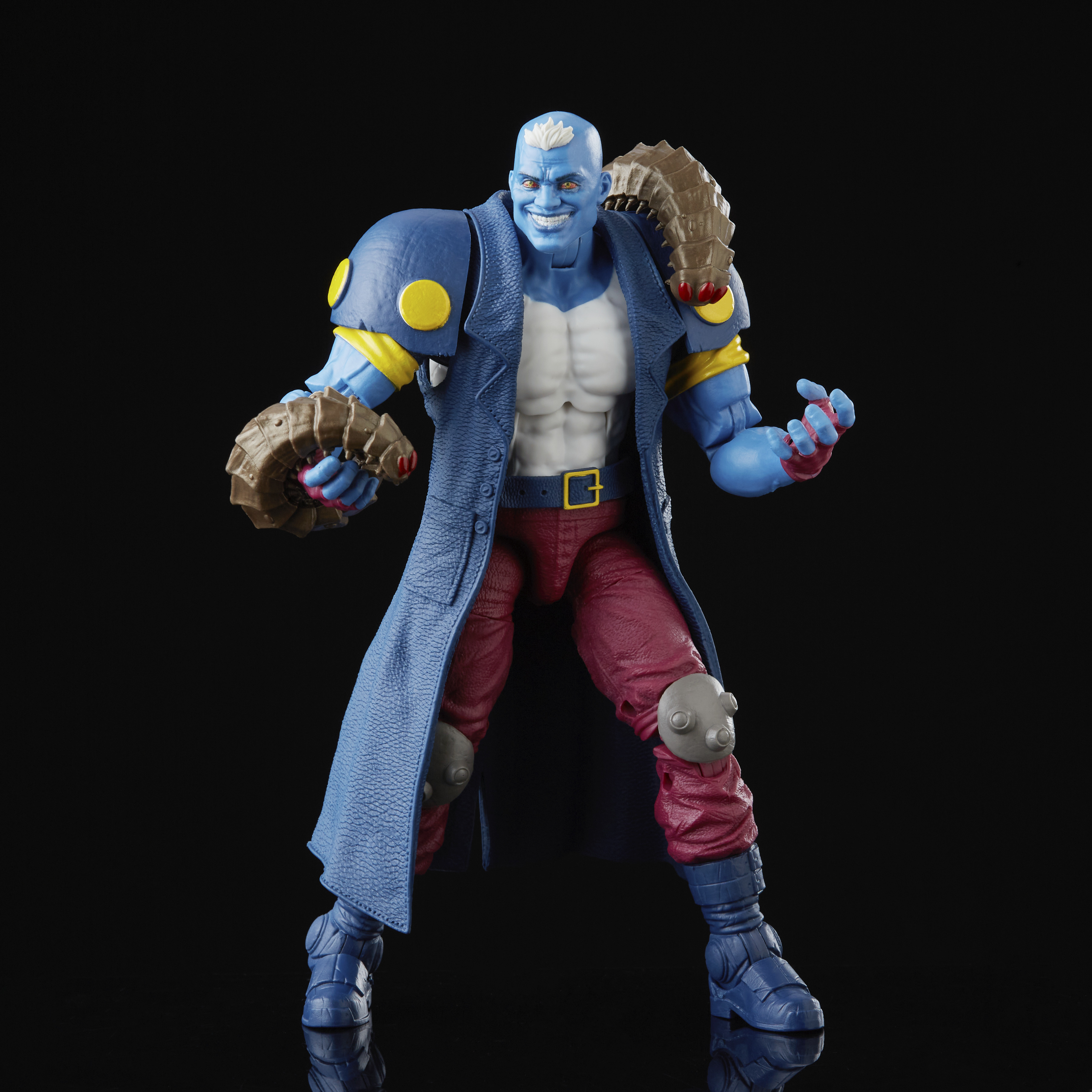 Action figure blu con un lungo cappotto, pantaloni rossi e accessori. Sfondo nero.