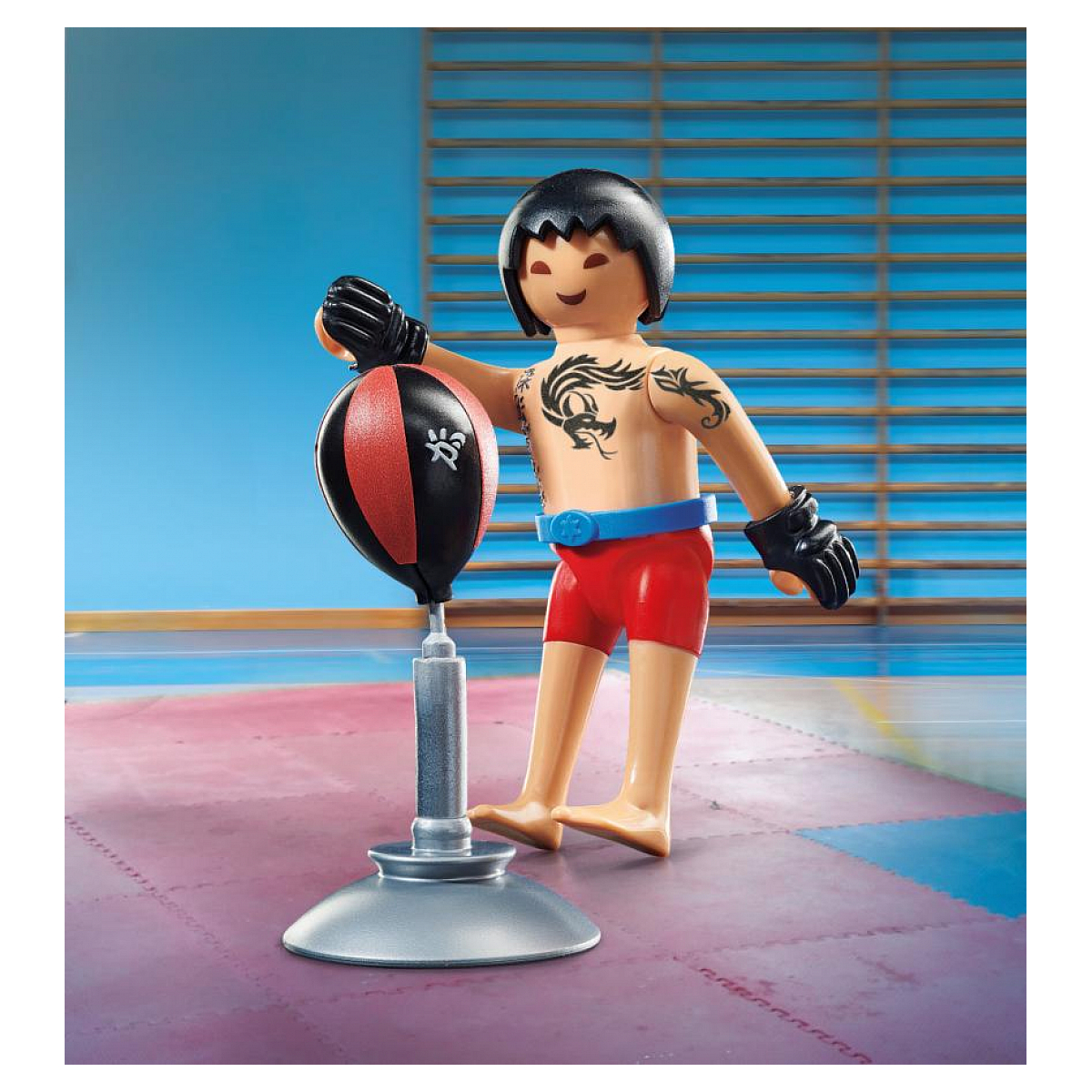 Figurka Playmobil mężczyzny z rękawicami bokserskimi i tatuażem obok worka treningowego.