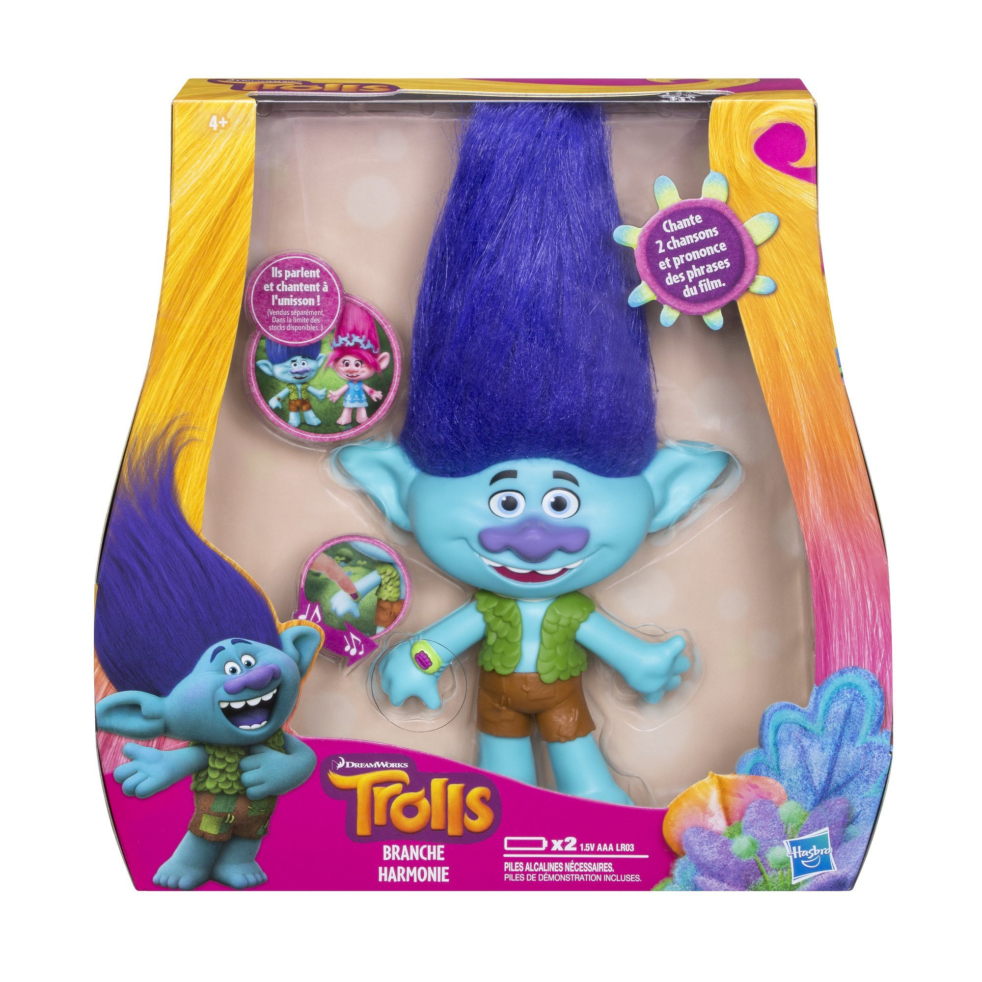 Un giocattolo dei Trolls in una scatola. Il troll è blu con i capelli viola e indossa un gilet verde.