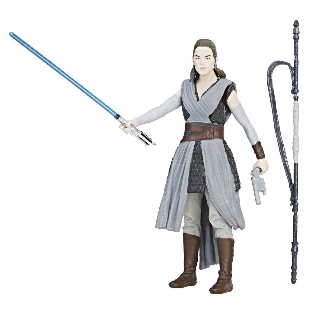 Una action figure di Rey con una spada laser e un accessorio. Indossa un abito grigio e si trova su una superficie bianca.