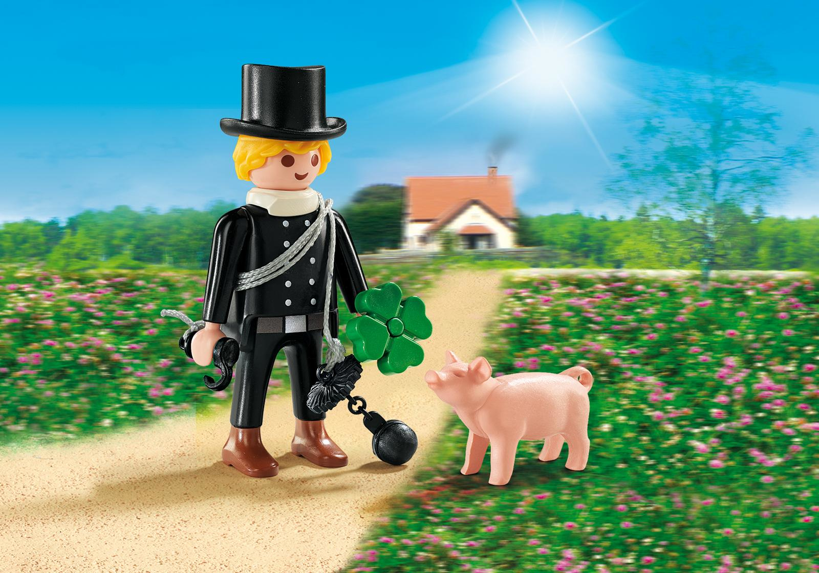 Eine Spielfigur eines Schornsteinfegers mit einem Schwein. Die Figur ist schwarz, trägt einen Zylinder und eine Bürste.