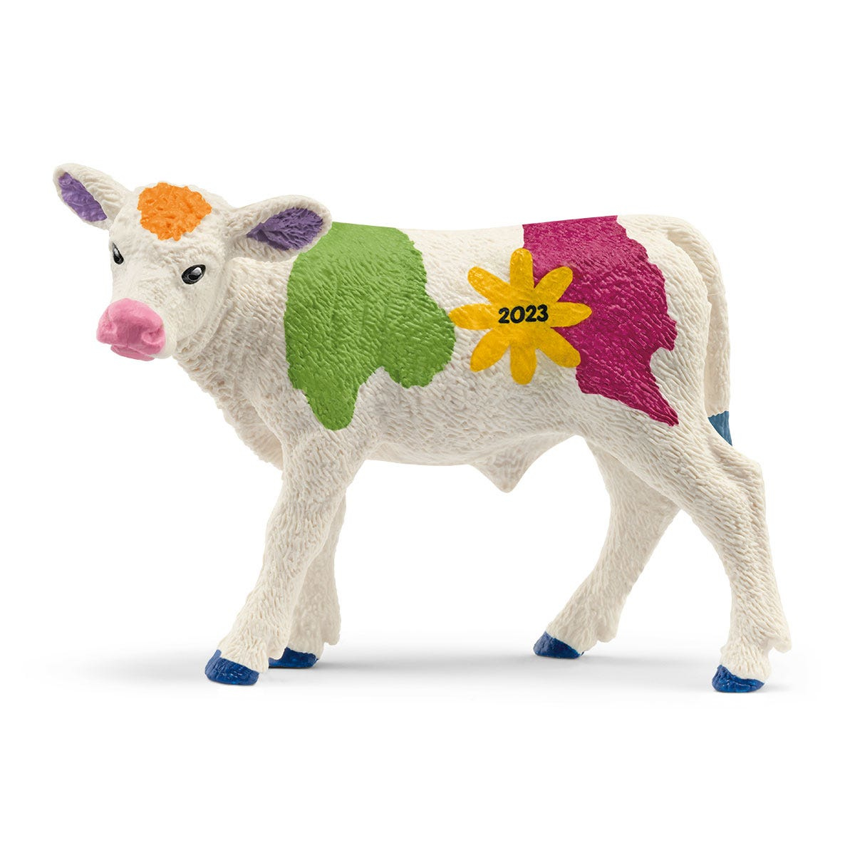 Mucca giocattolo bianca con macchie di vernice colorate. Ha naso rosa, zoccoli blu e un fiore giallo sul lato.