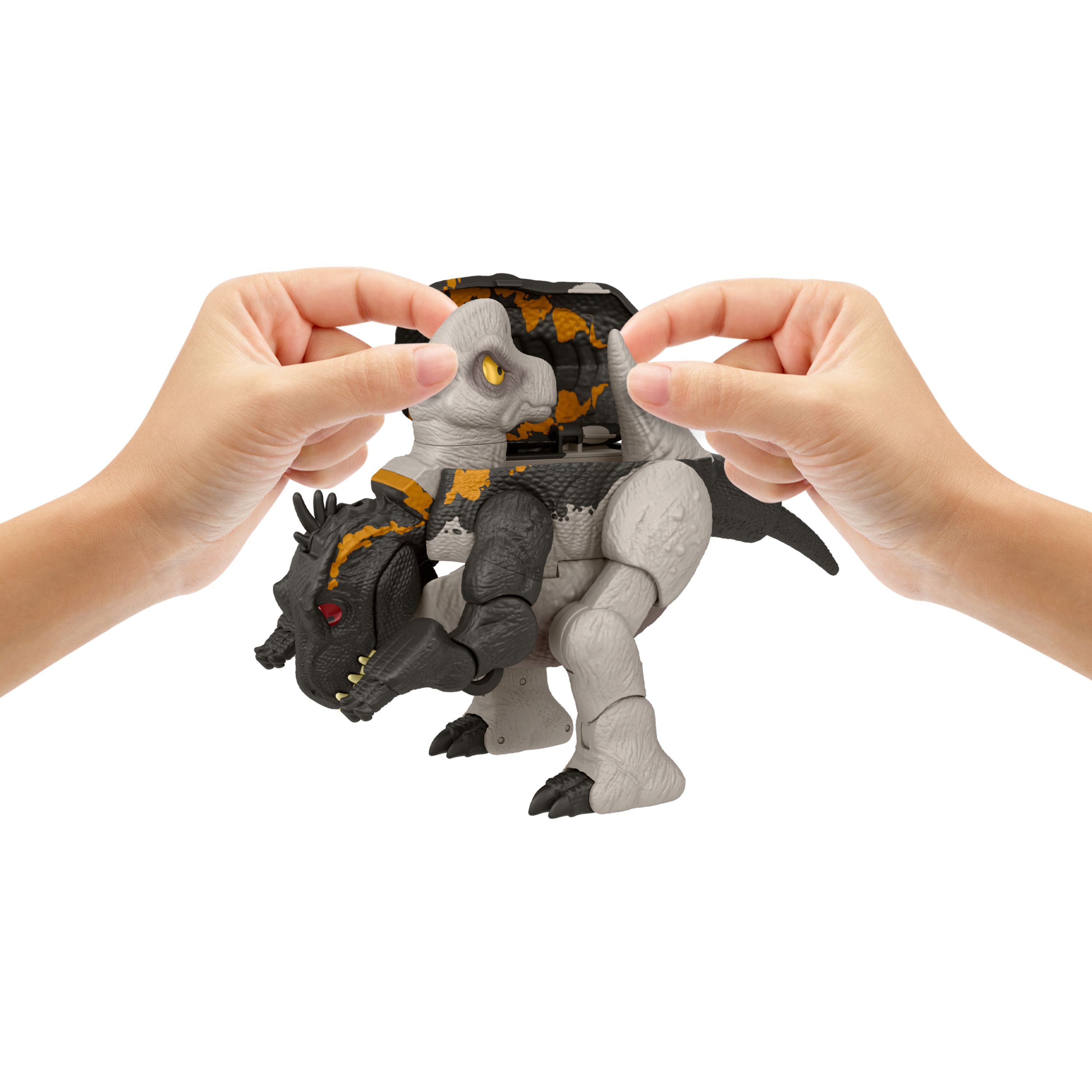 Hände halten ein zweiteiliges Spielzeug-Dinosaurier. Es ist grau und schwarz mit gelben Augen.