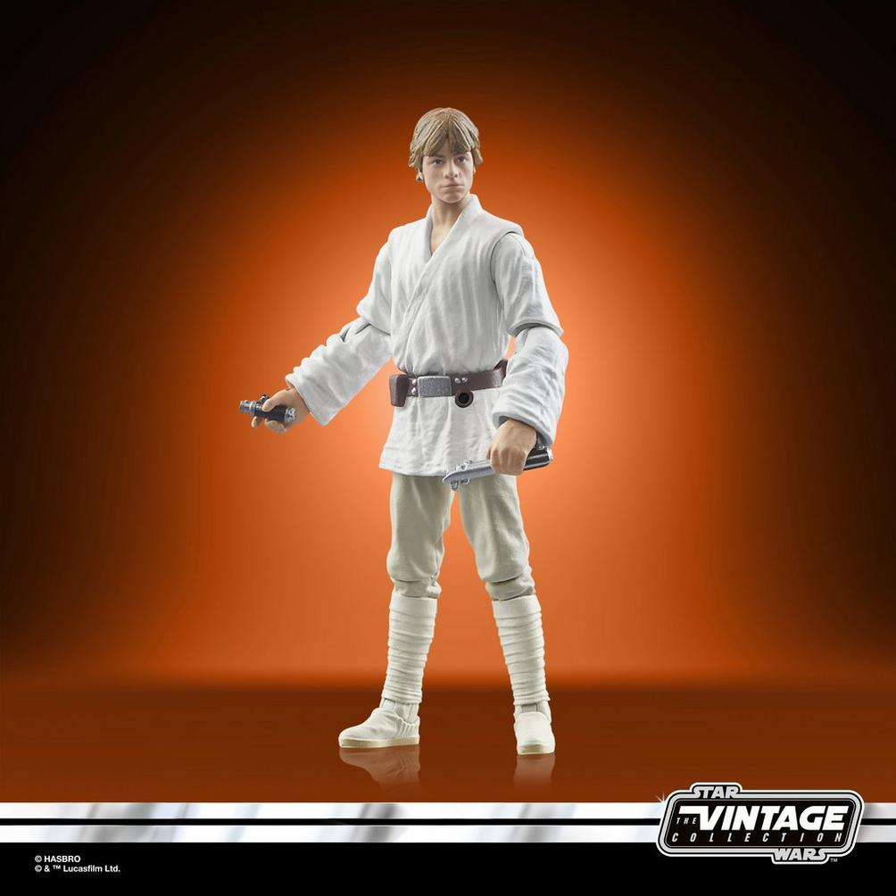 Luke Skywalker-Actionfigur in weißem Outfit, hält ein Lichtschwert. Oranger Hintergrund.