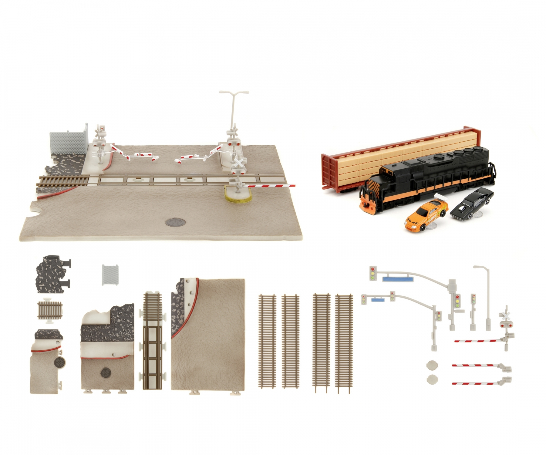 Zestaw zabawek kolejowych z torami, pociągiem, rogatkami i innymi akcesoriami na białej powierzchni.