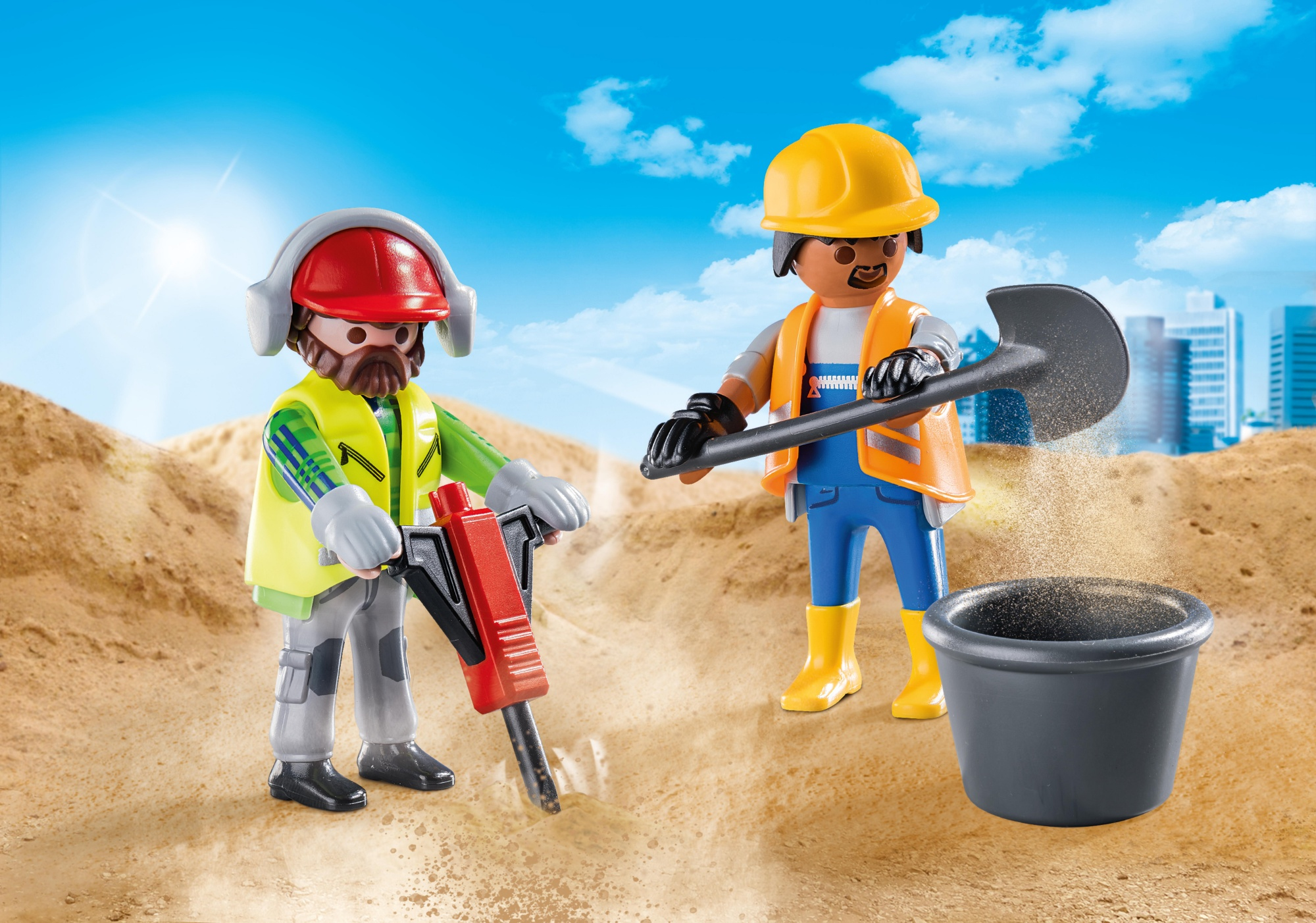 Zwei Bauarbeiter mit Werkzeugen und Sand. Einer benutzt einen Presslufthammer, der andere schaufelt Sand in einen Eimer.