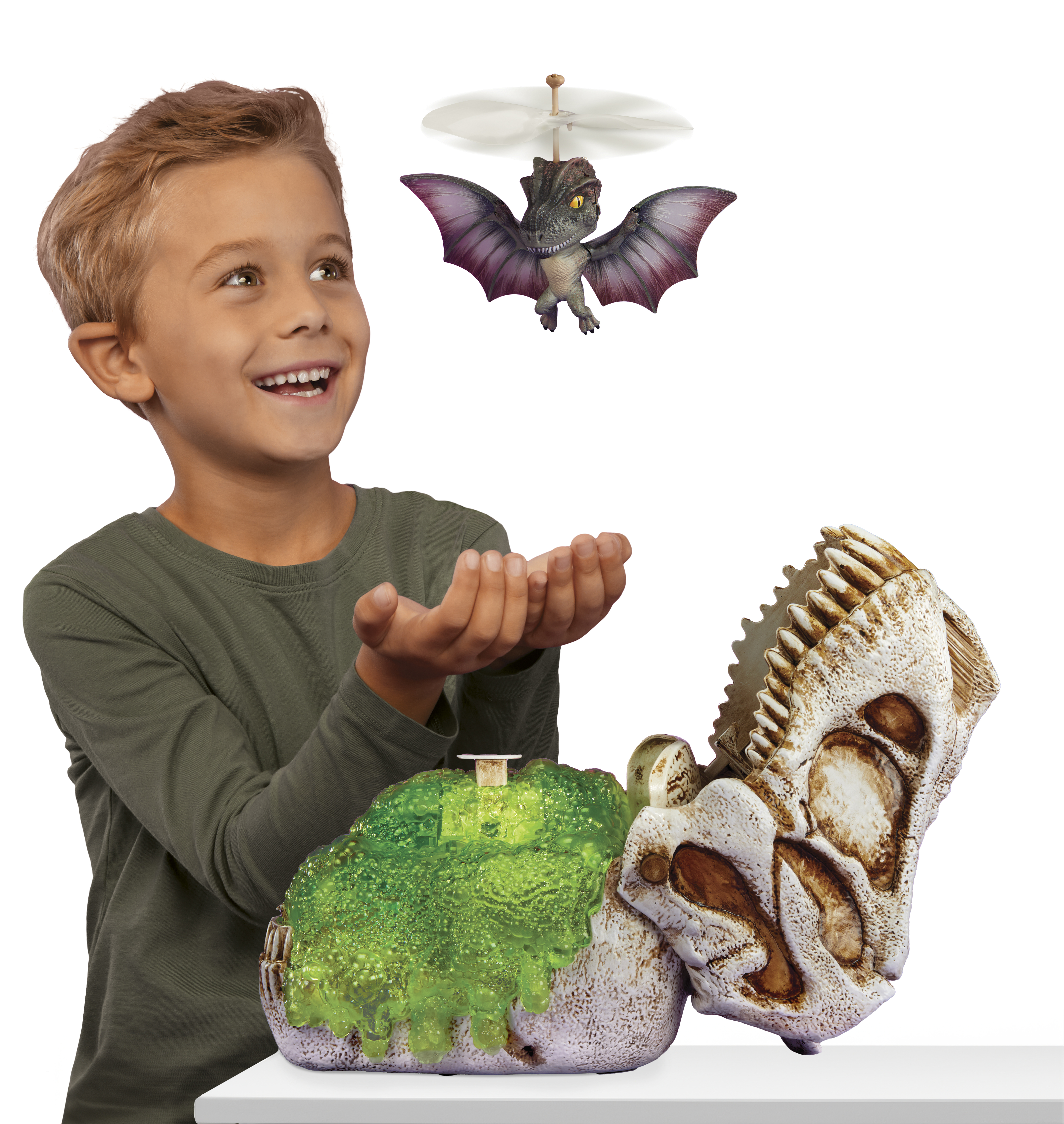 Un niño está emocionado de jugar con un juguete de dinosaurio volador. Una base verde y una calavera están cerca de él.