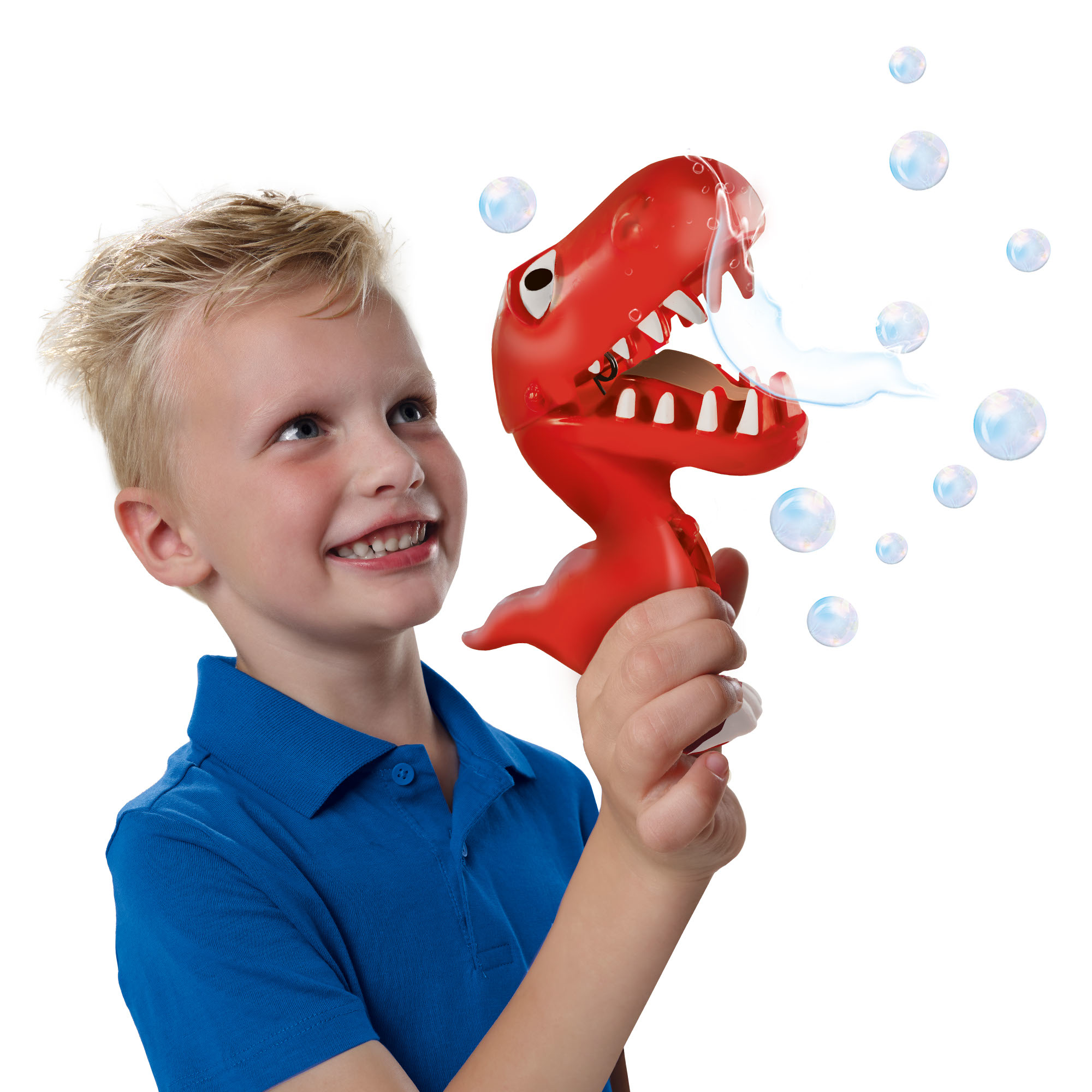 Un niño sostiene un burbujeador de dinosaurio rojo, soplando burbujas. Está sonriendo y el fondo es blanco.