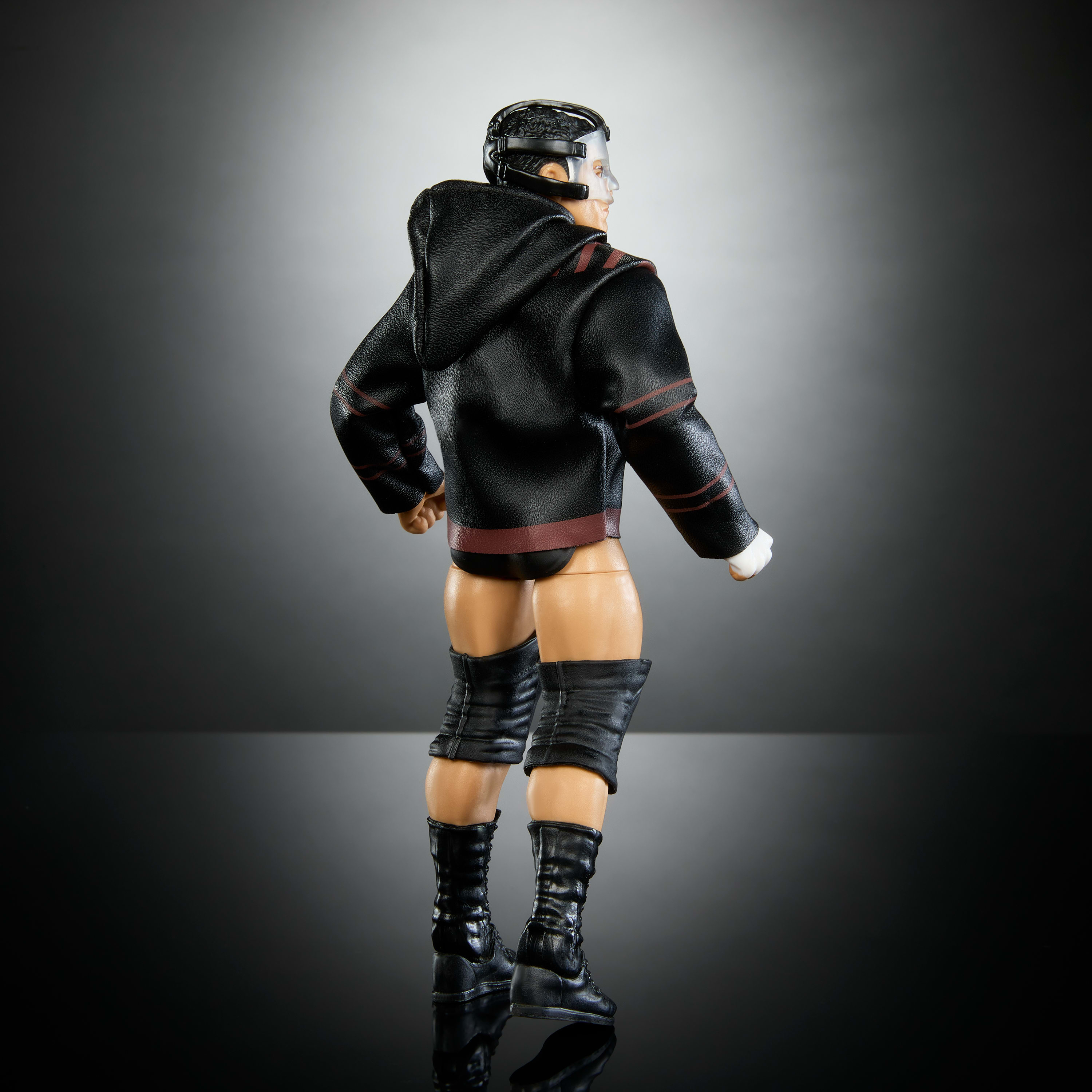 Vista posteriore di un action figure, un lottatore in abito nero e rosso su una superficie riflettente.