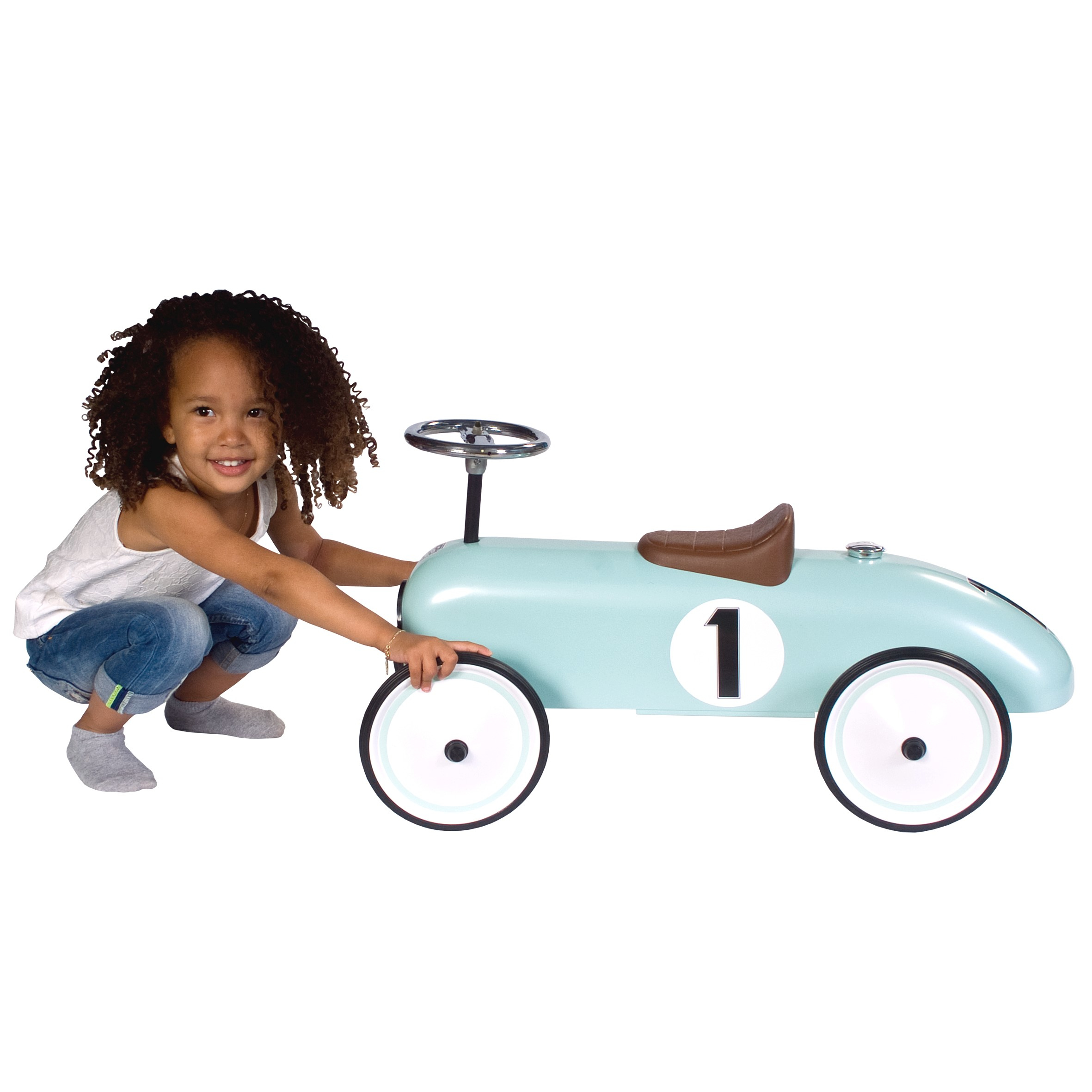 Una bambina si china accanto a un'auto da corsa giocattolo blu con il numero 1 sul lato, sfondo bianco.