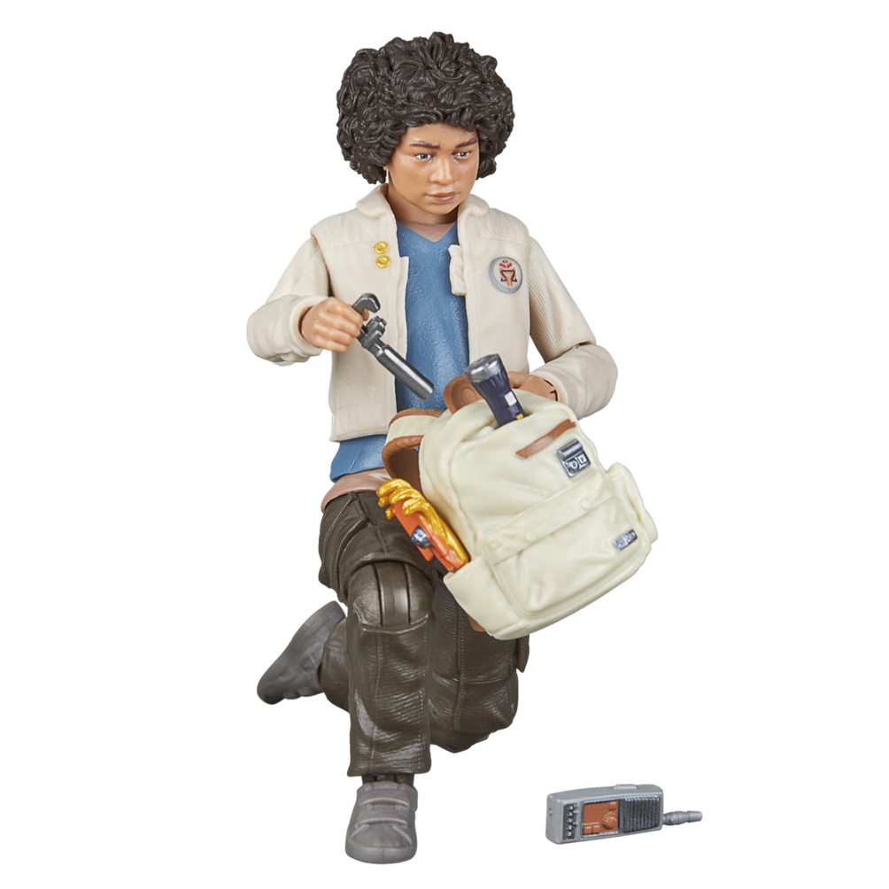 Figurka osoby w beżowej kurtce, trzymającej latarkę i plecak, klęczącej.