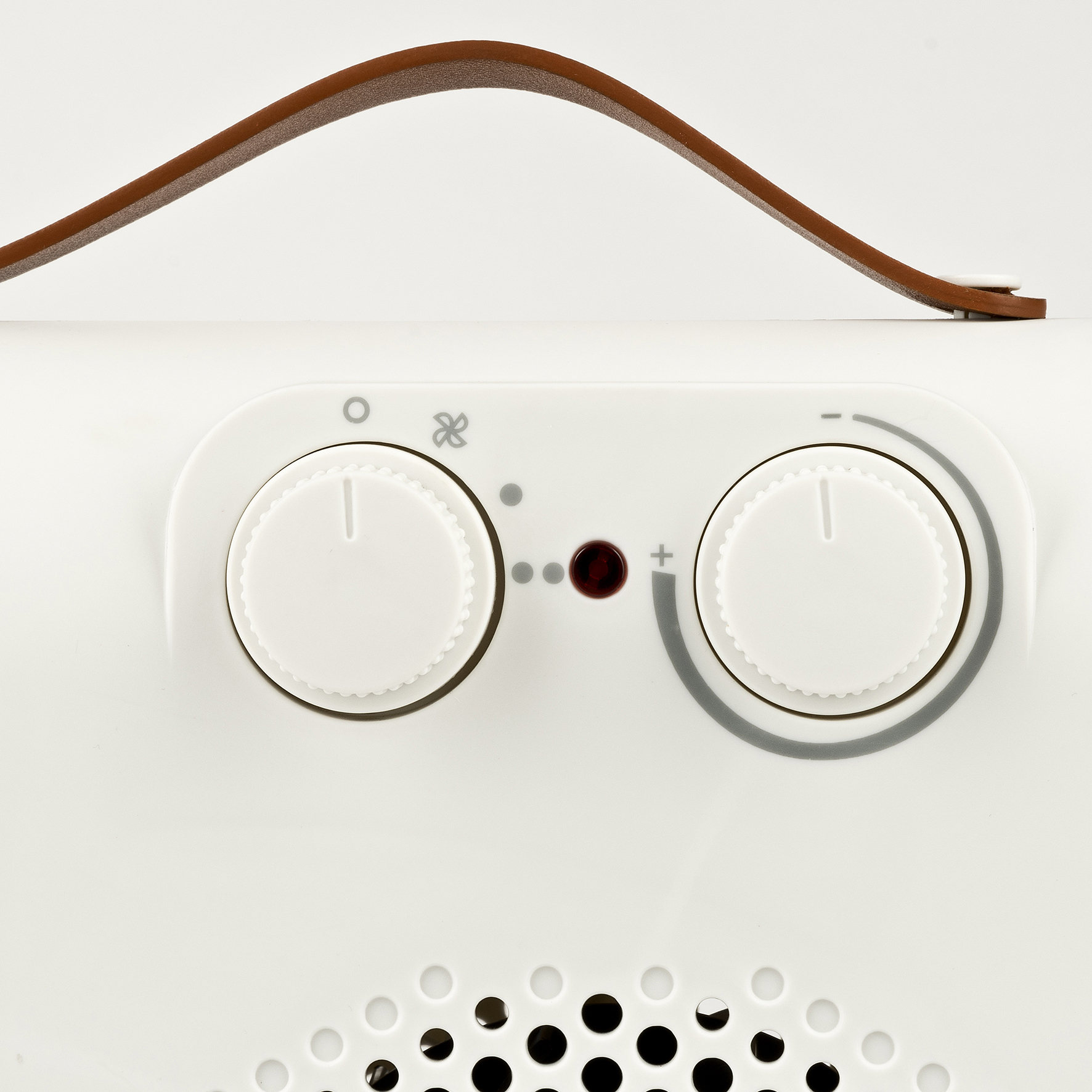 Primo piano dei comandi del termoventilatore: due manopole e una luce rossa, manico marrone sopra.
