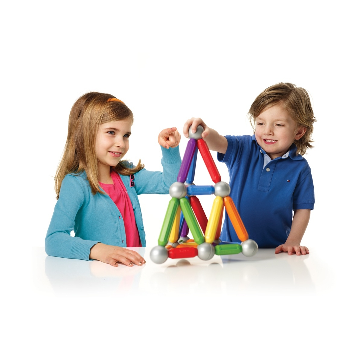 Due bambini giocano con un colorato set di costruzioni magnetiche.