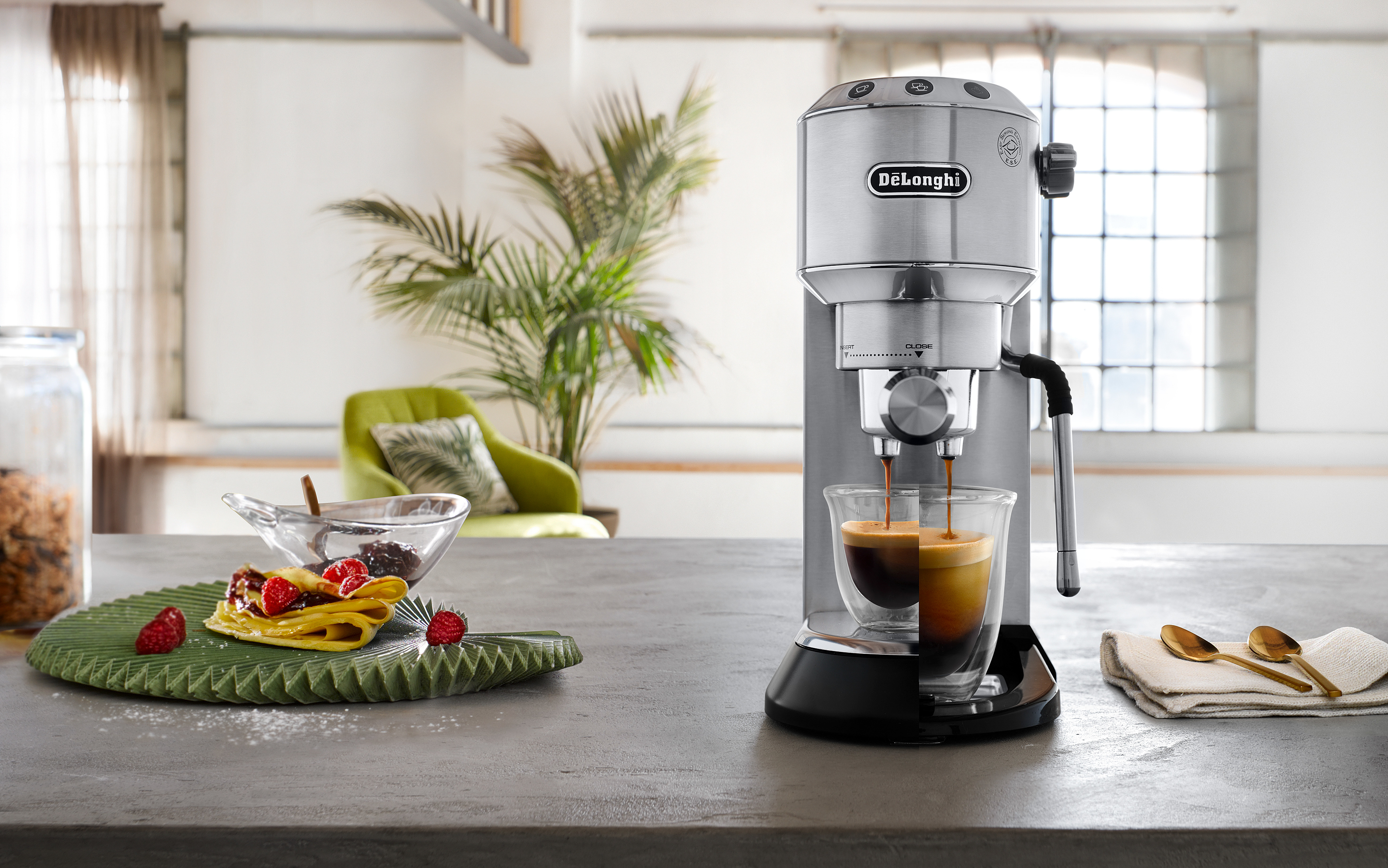 Espressomaschine, die Kaffee in ein klares Glas brüht. Beeren und Essen auf einem Holztablett.
