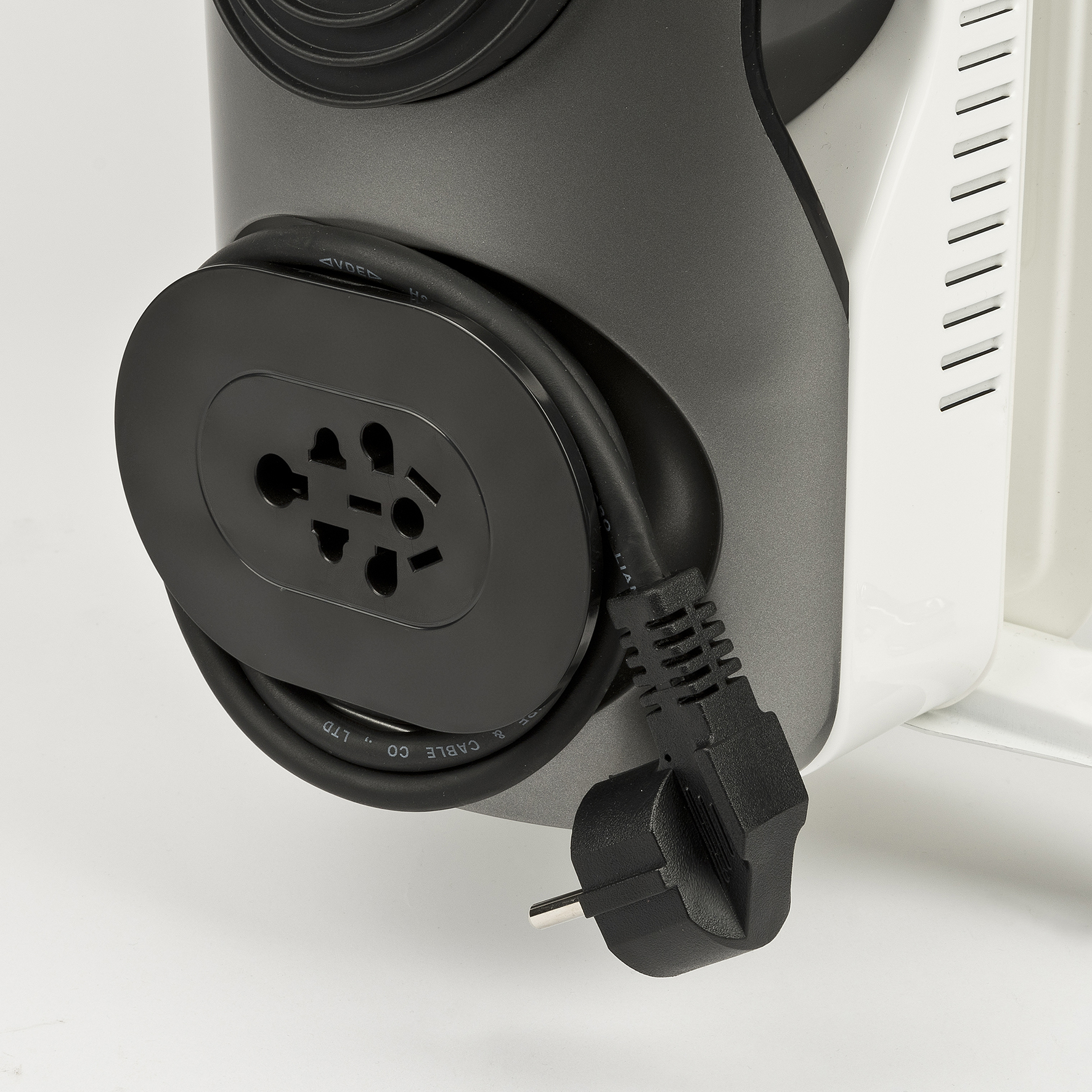 Zbliżenie urządzenia elektrycznego z czarnym przewodem zasilającym owiniętym wokół urządzenia.