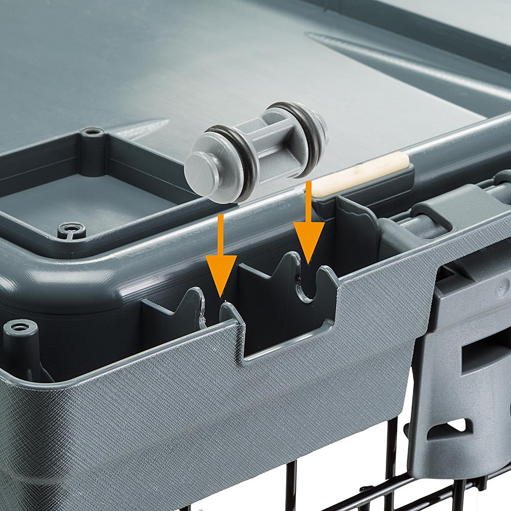Nahaufnahme der grauen Kunststoffbasis einer Haustierbox mit Verriegelungsmechanismus.