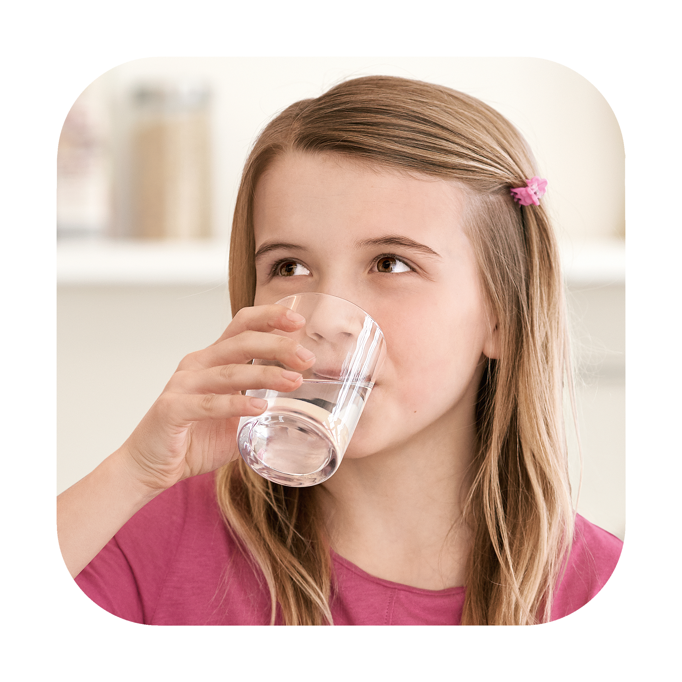 Ragazza che beve acqua da un bicchiere. Ha i capelli biondi e indossa una maglietta rosa.