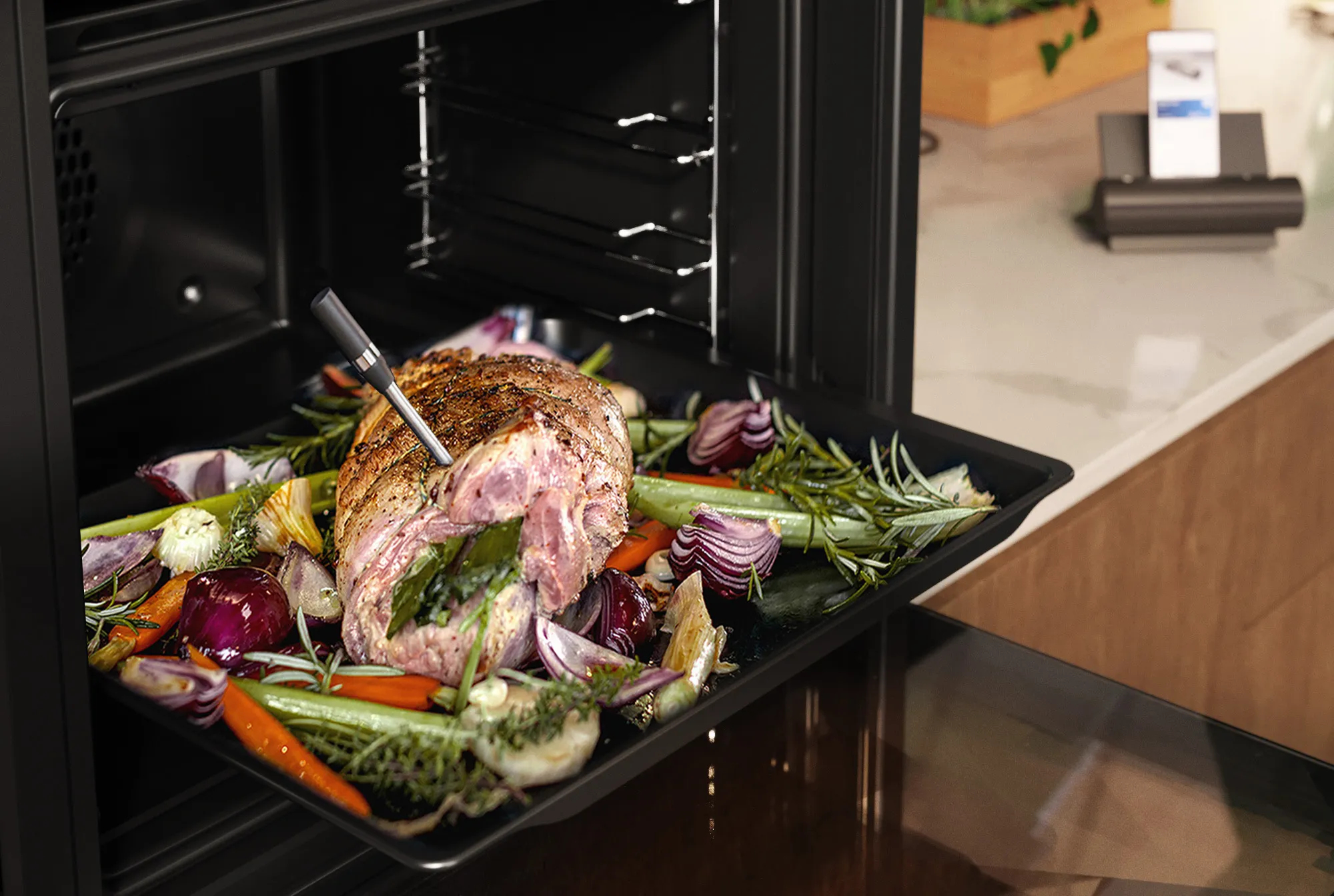 Fleisch und Gemüse auf einem Tablett in einem Ofen. Ein Thermometer wird in das Fleisch gesteckt.