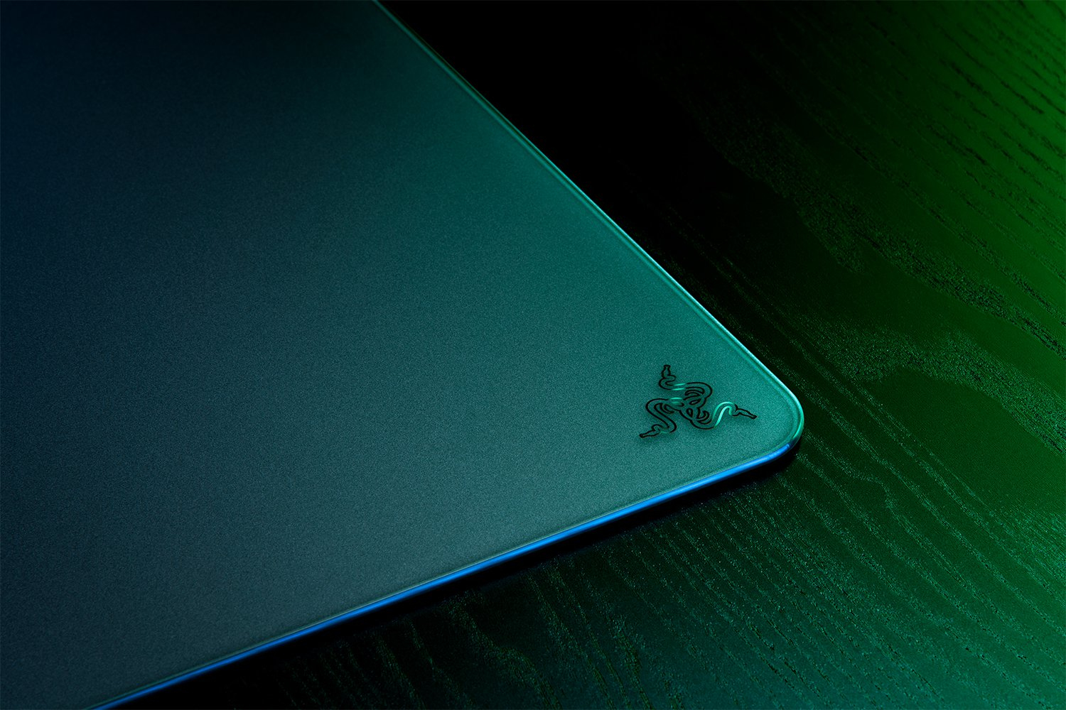 Ciemna podkładka pod mysz gamingową z zielonym logo Razer w rogu.