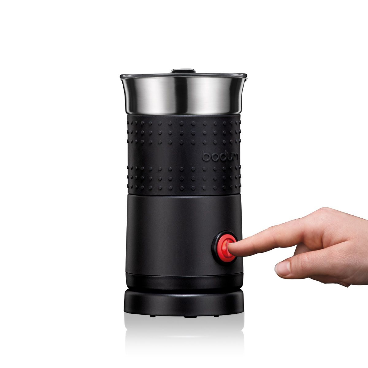 Czarny i srebrny spieniacz do mleka z czerwonym przyciskiem wciskanym przez dłoń.