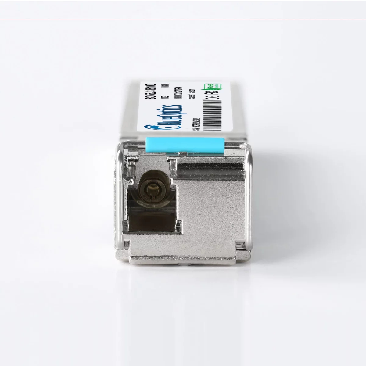 Srebrny moduł sieciowy z etykietą BlueOptics. Widok z przodu. Jasnoniebieski pasek. Szczegóły i kod kreskowy na etykiecie.