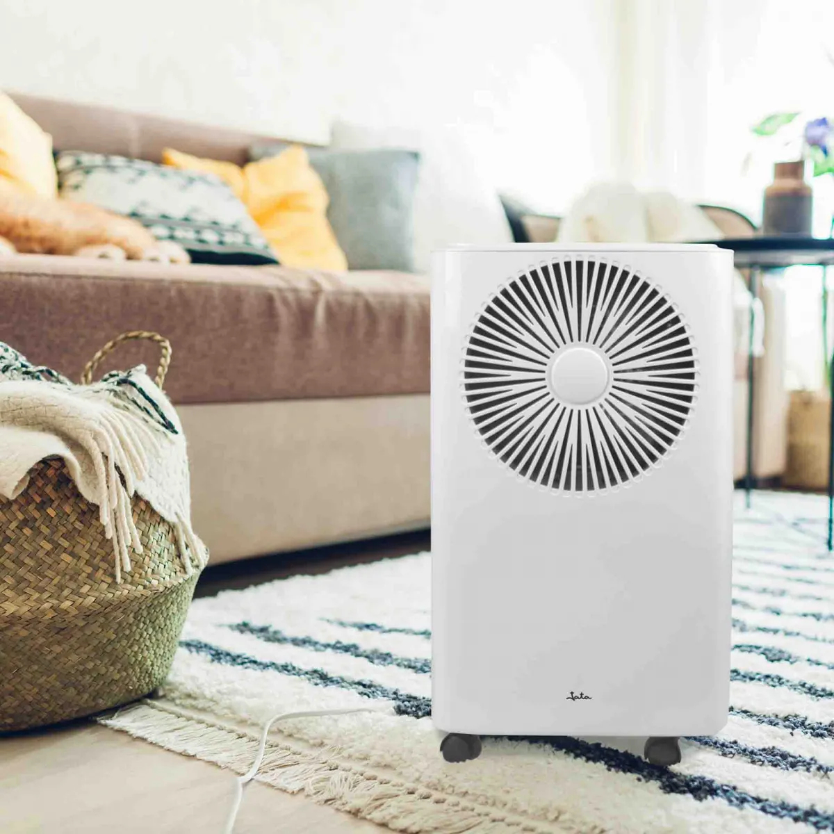 Purificatore d'aria bianco con ventola circolare. Divano ed elementi decorativi sullo sfondo.